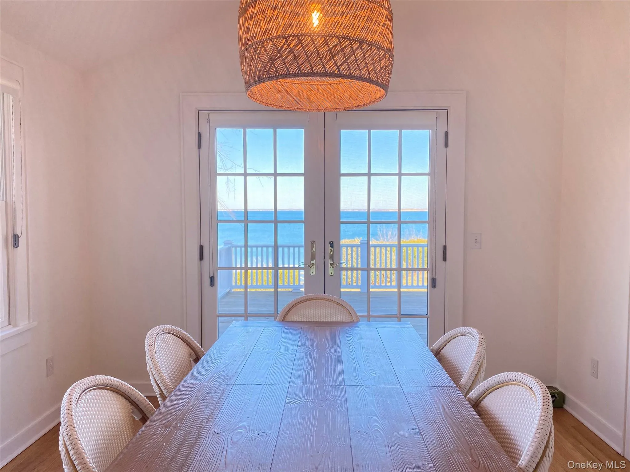 Dining space featuring wood finished floors, a water view, french doors, and plenty of natural light Dining space featuring wood finished floors, a water view, french doors, and plenty of natural light