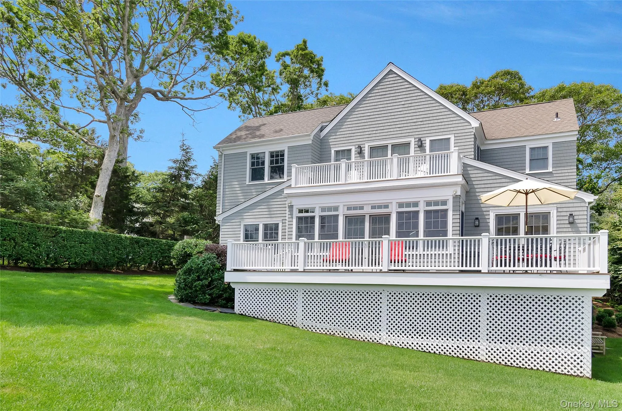 Rear view of property featuring a yard, a shingled roof, and a wooden deck Rear view of property featuring a yard, a shingled roof, and a wooden deck