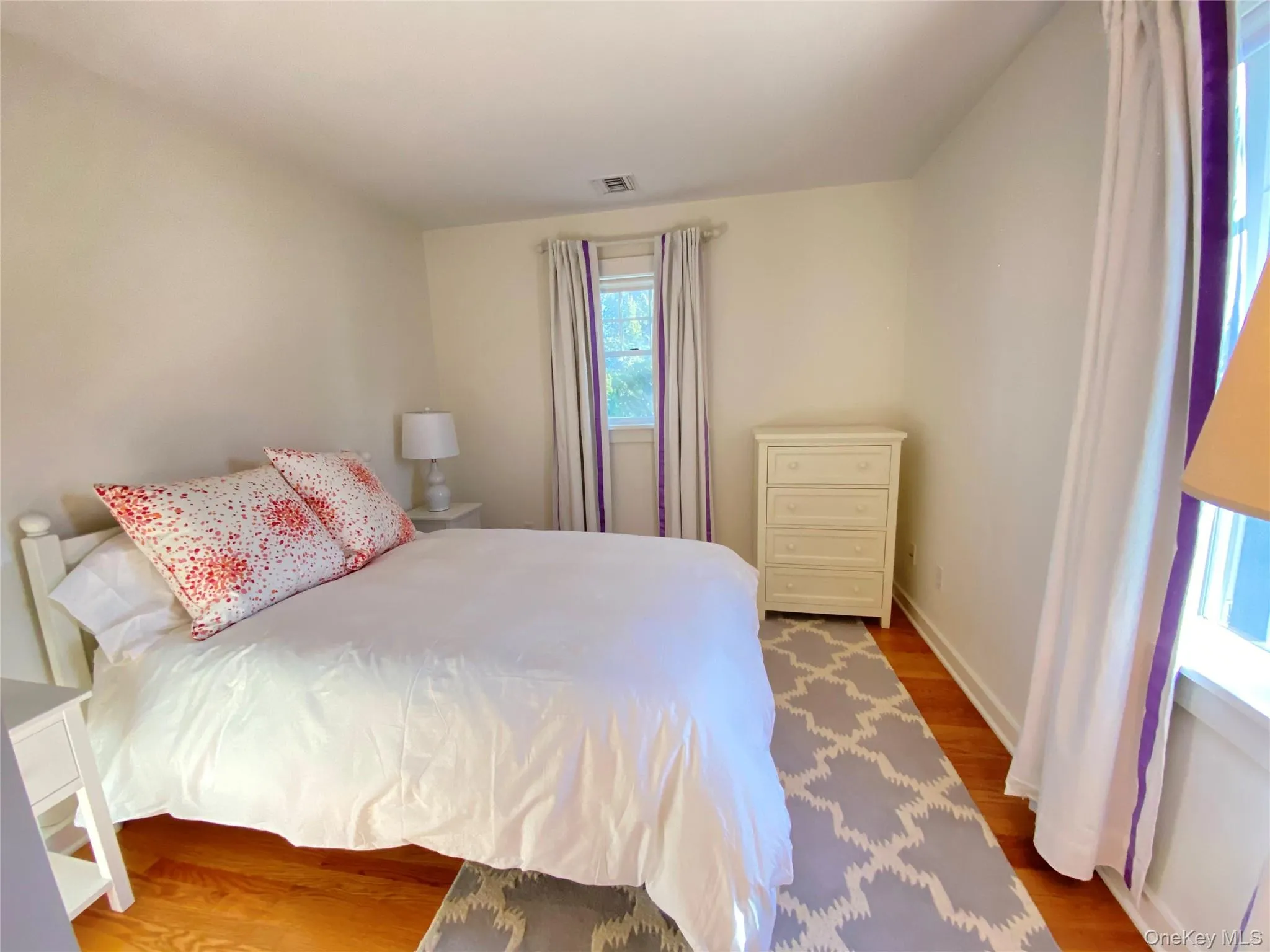 Bedroom featuring wood finished floors and baseboards Bedroom featuring wood finished floors and baseboards