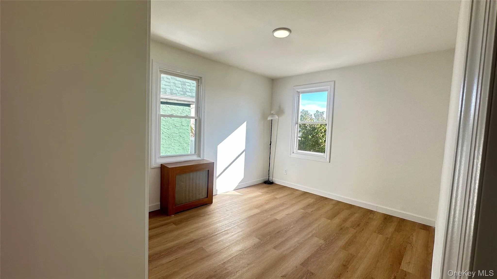Spare room featuring radiator and light wood-style floors Spare room featuring radiator and light wood-style floors