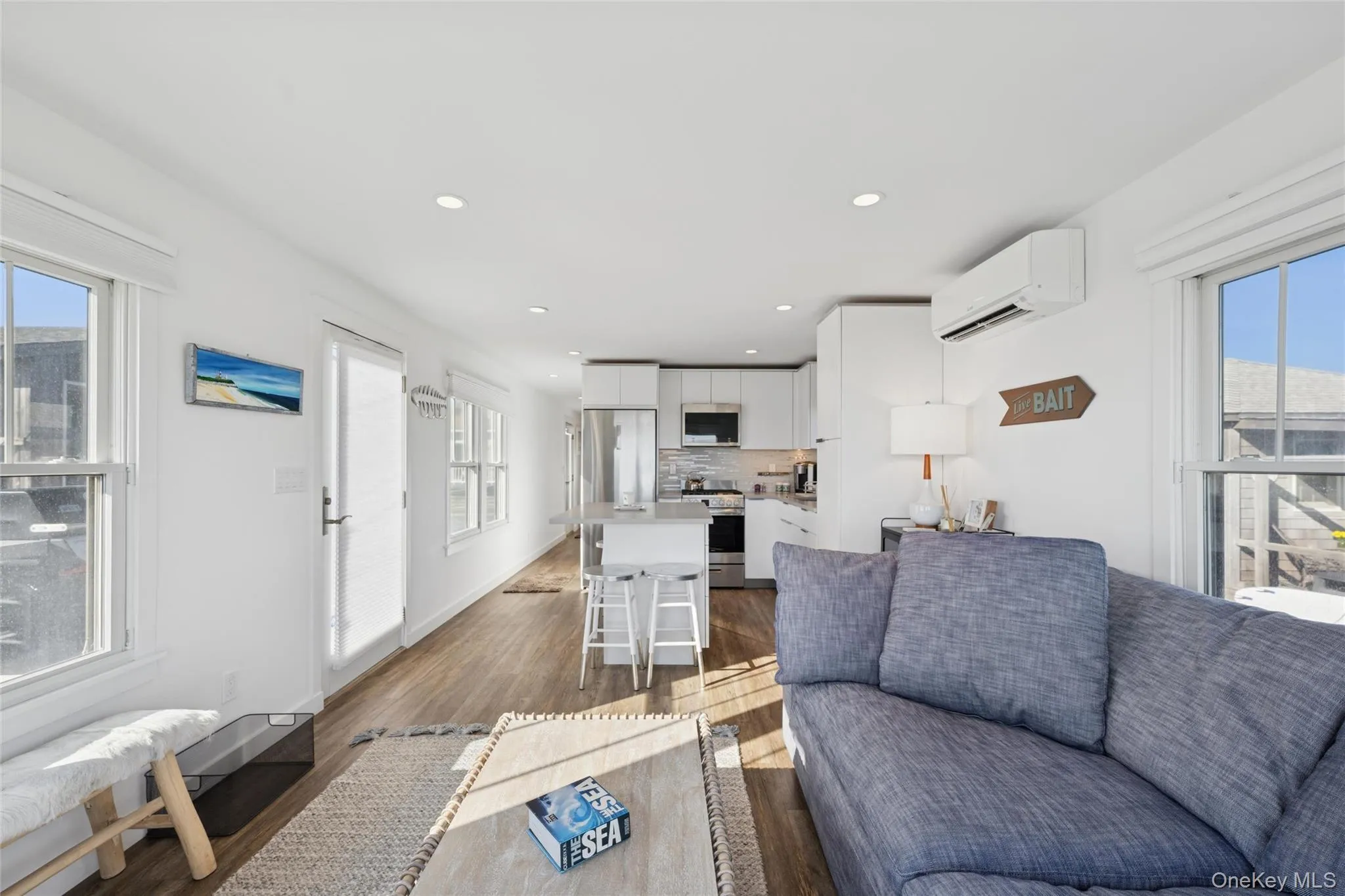 Living room featuring dark wood-style floors, recessed lighting, and a wall mounted air conditioner Living room featuring dark wood-style floors, recessed lighting, and a wall mounted air conditioner