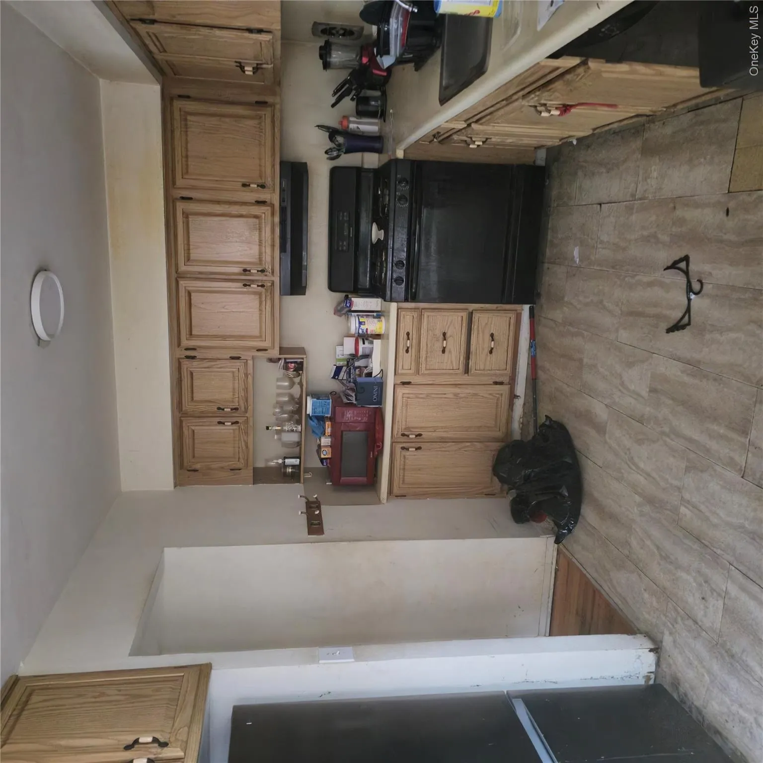 Kitchen with range, light countertops, fridge, white microwave, and range hood Kitchen with range, light countertops, fridge, white microwave, and range hood