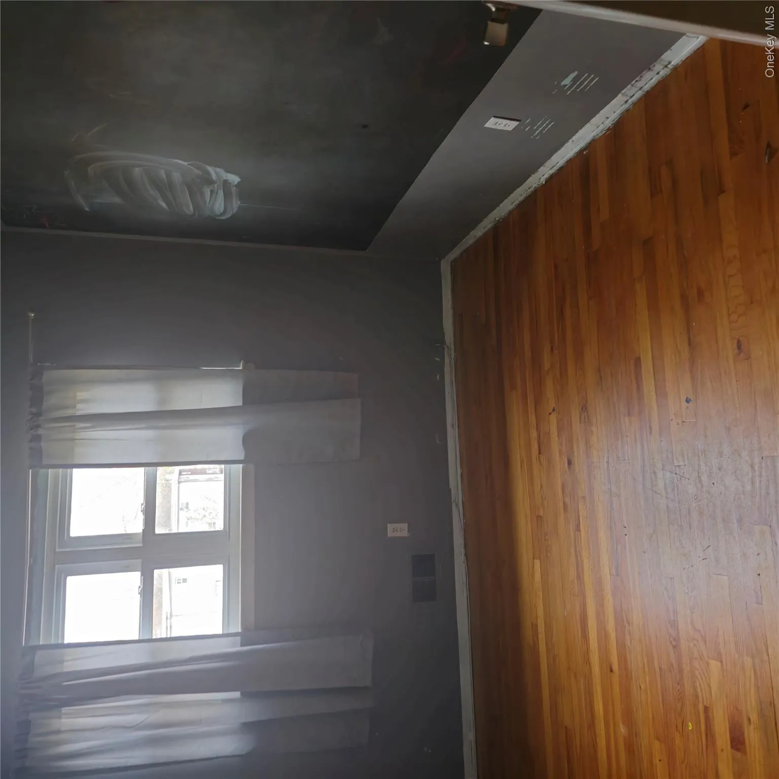 Spare room featuring baseboards and hardwood / wood-style floors Spare room featuring baseboards and hardwood / wood-style floors