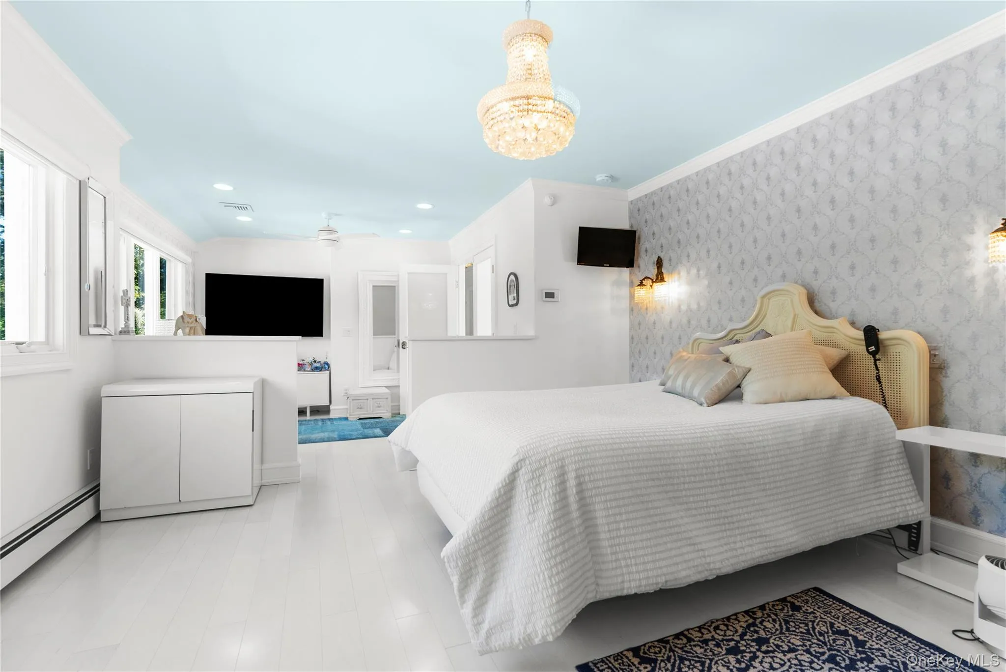 Bedroom with crown molding, wallpapered walls, a baseboard heating unit, a chandelier, and recessed lighting Bedroom with crown molding, wallpapered walls, a baseboard heating unit, a chandelier, and recessed lighting