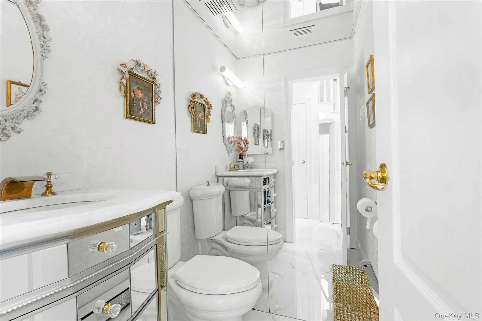 Bathroom featuring vanity and light marble finish floors Bathroom featuring vanity and light marble finish floors