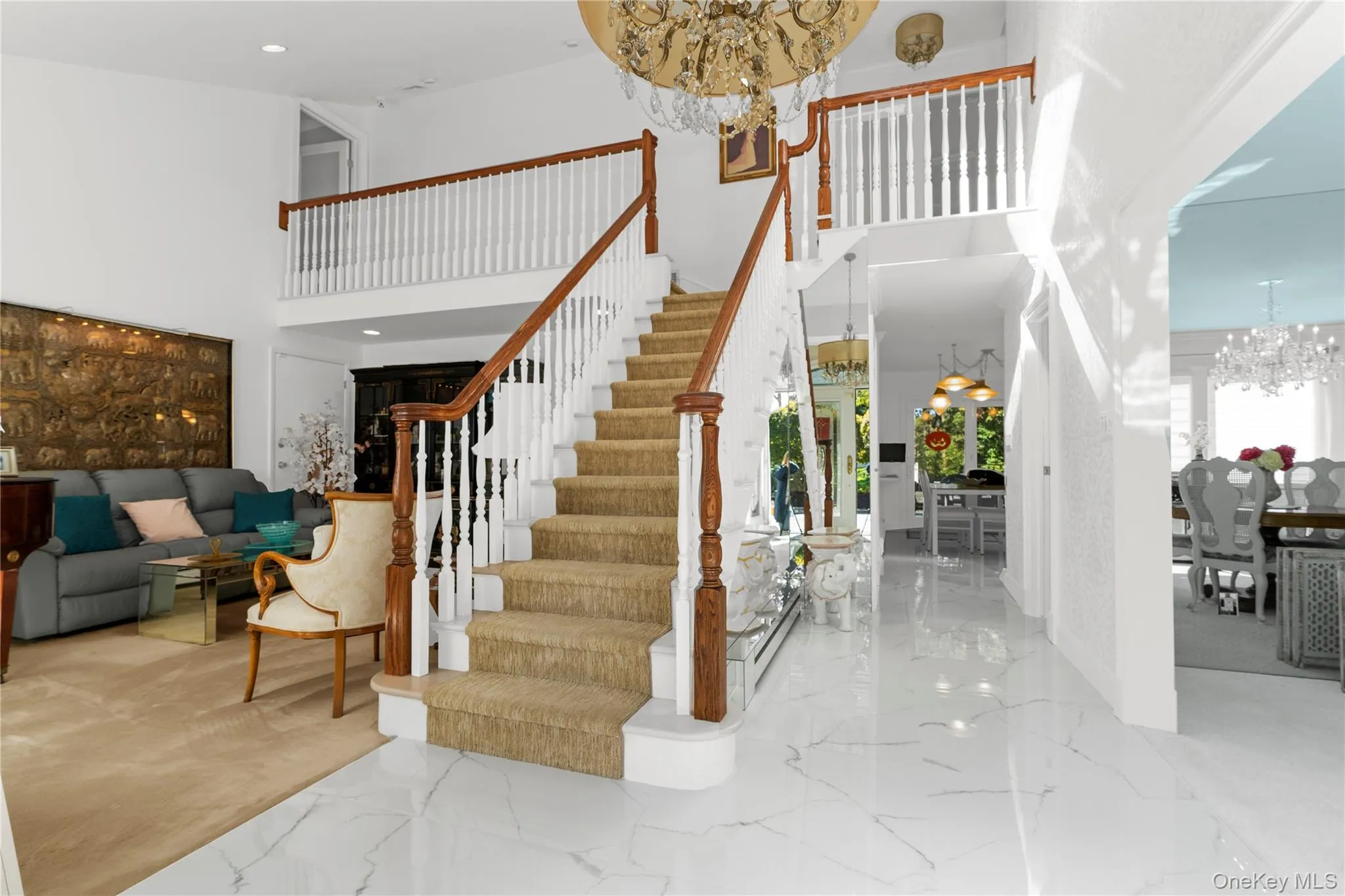 Stairs with a chandelier, marble tiled floors, a high ceiling, and recessed lighting Stairs with a chandelier, marble tiled floors, a high ceiling, and recessed lighting