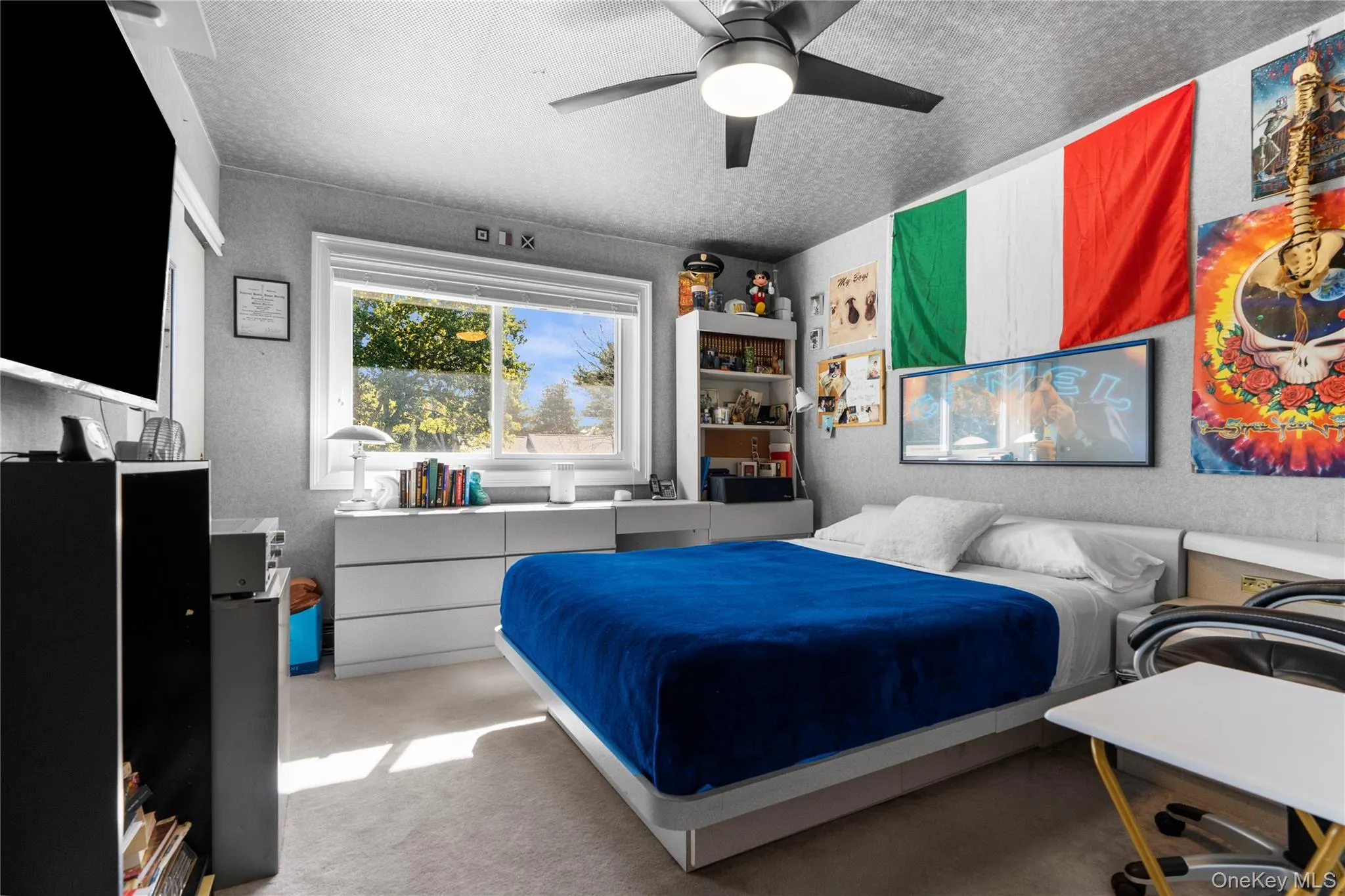 Bedroom featuring carpet flooring, a ceiling fan, and a textured ceiling Bedroom featuring carpet flooring, a ceiling fan, and a textured ceiling