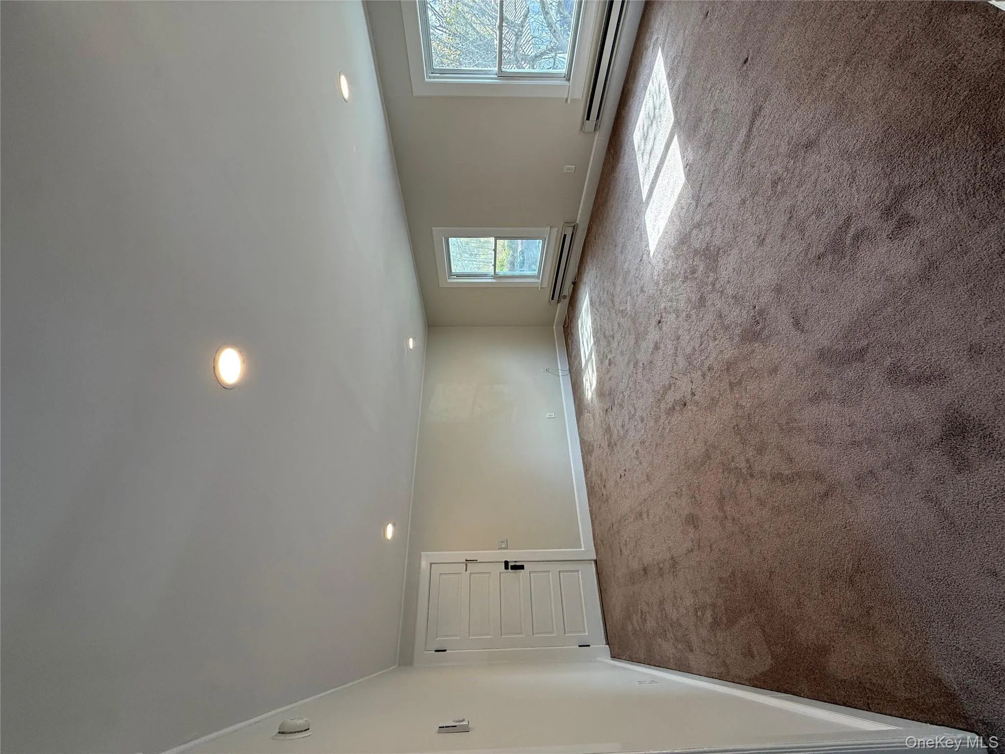 Empty room with carpet floors, recessed lighting, and a baseboard heating unit Empty room with carpet floors, recessed lighting, and a baseboard heating unit