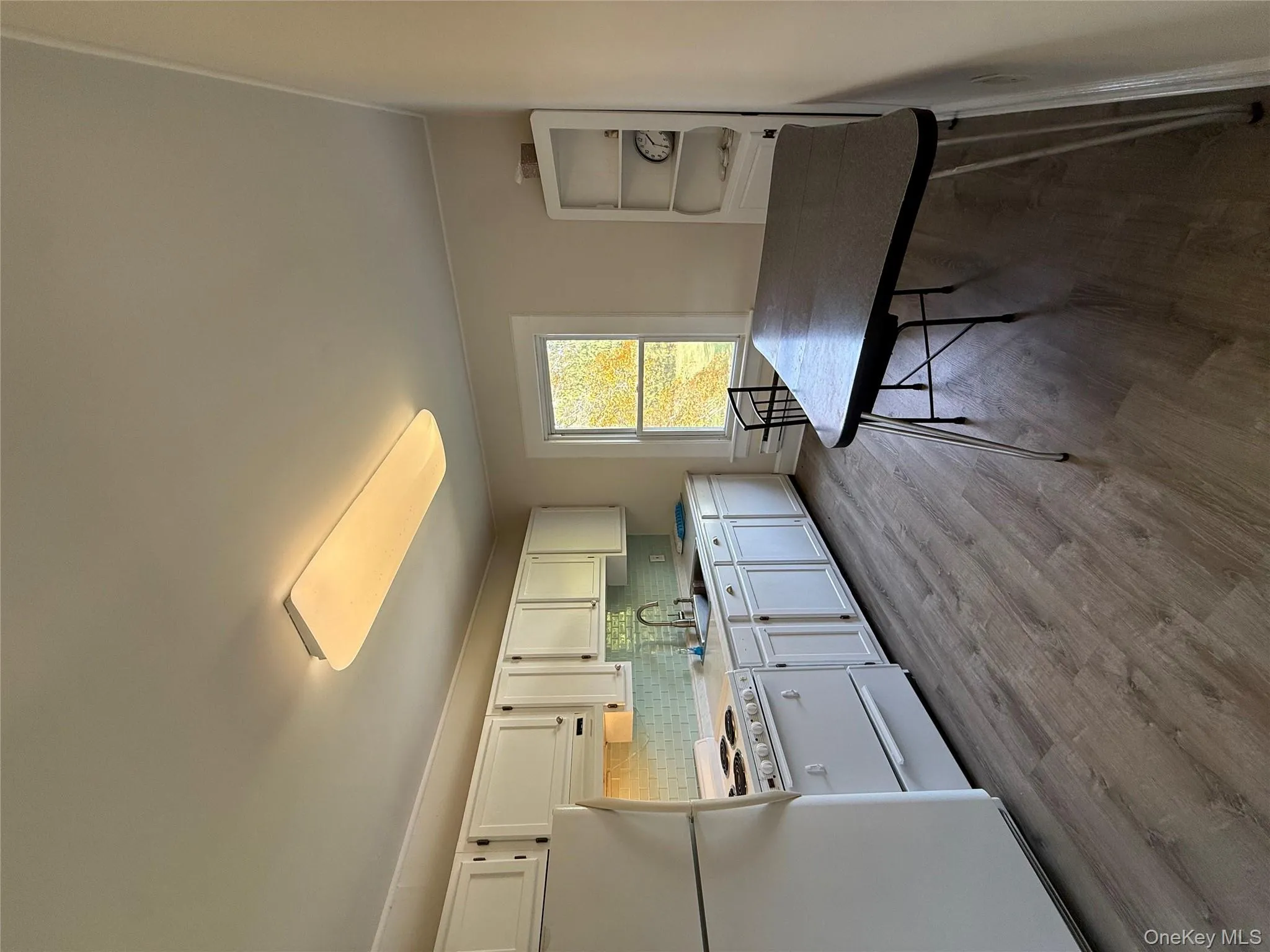 Kitchen with tasteful backsplash, fridge, light wood-style floors, stove, and light countertops Kitchen with tasteful backsplash, fridge, light wood-style floors, stove, and light countertops