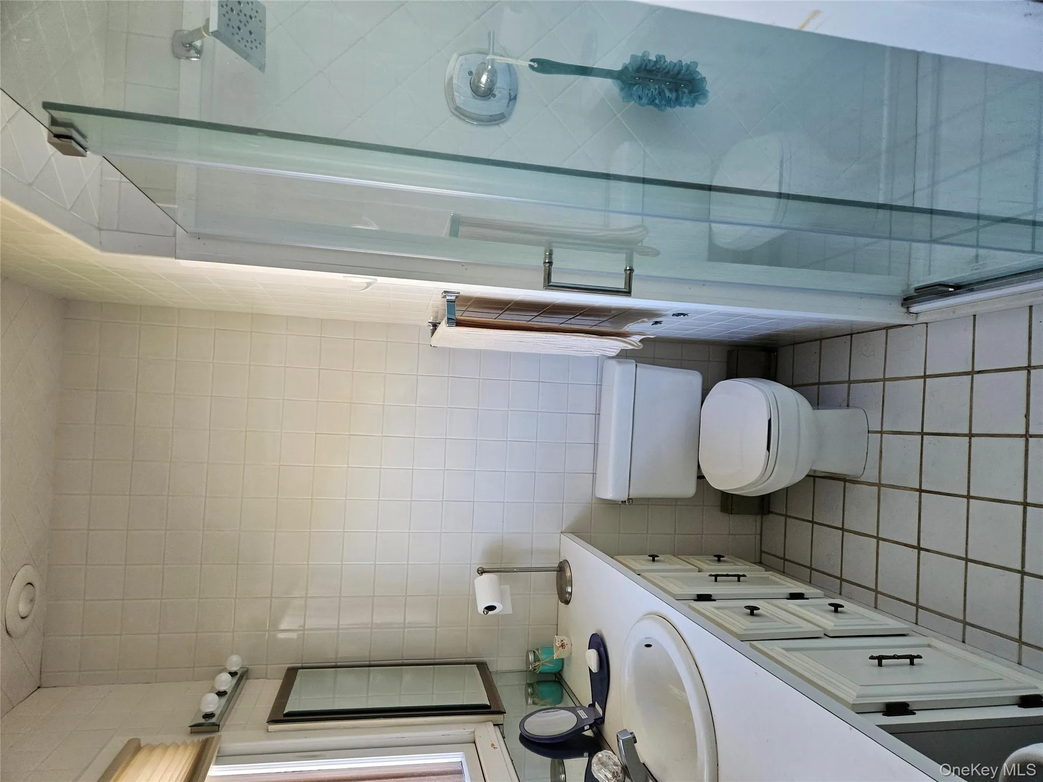 Full bath with light tile patterned flooring, vanity, tile walls, and a shower stall Full bath with light tile patterned flooring, vanity, tile walls, and a shower stall