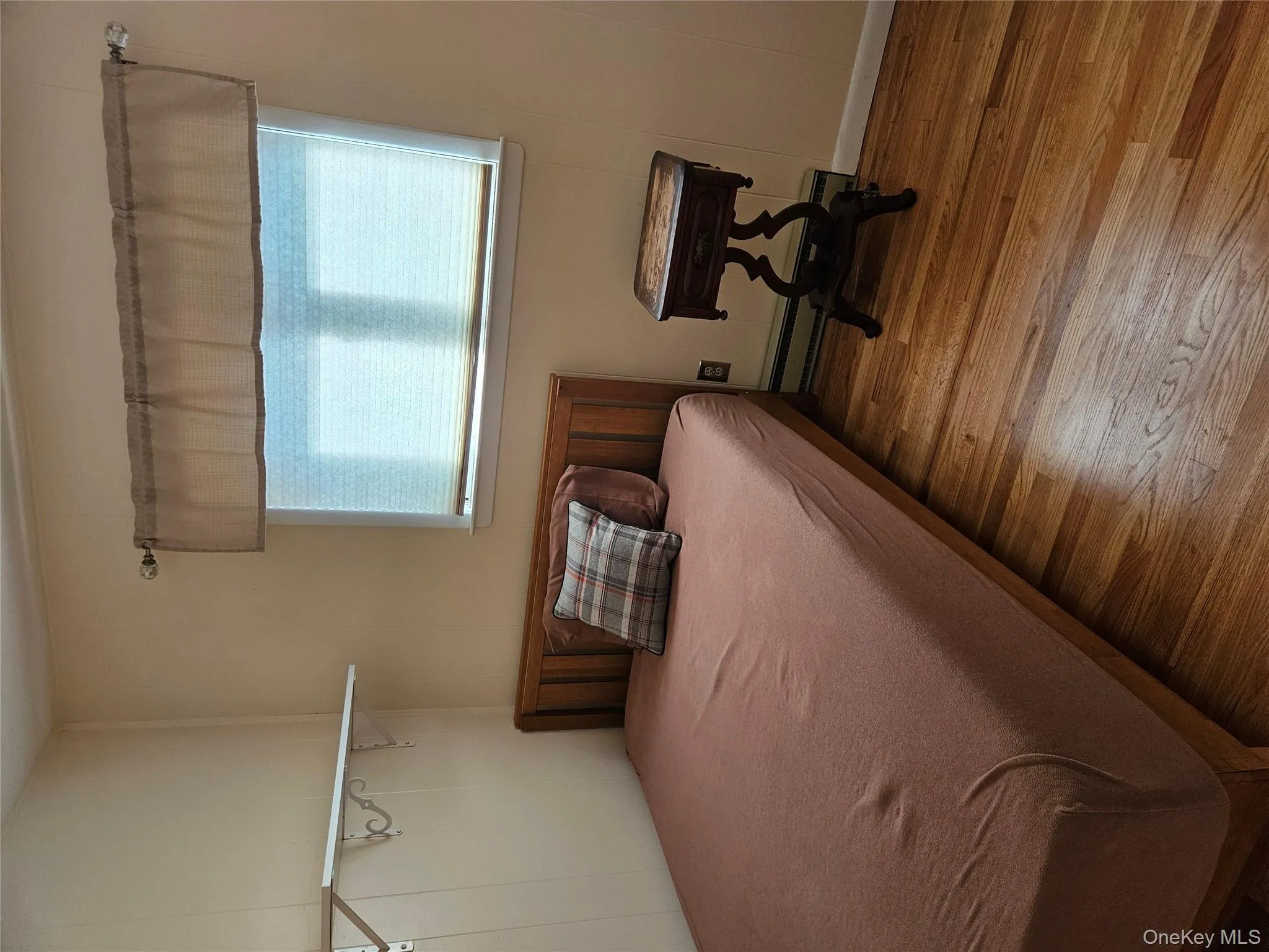 Bedroom featuring multiple windows, wood-type flooring, and baseboard heating Bedroom featuring multiple windows, wood-type flooring, and baseboard heating