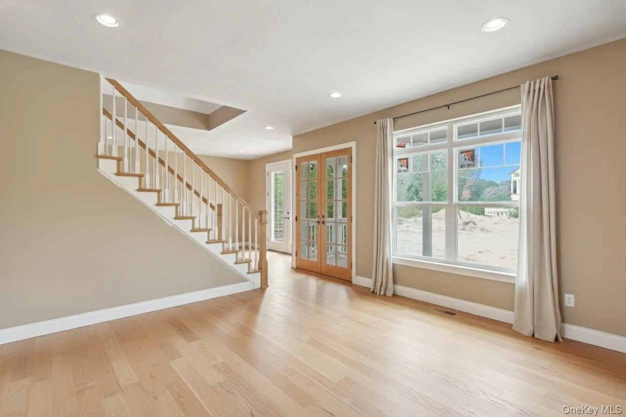 Foyer featuring french doors, stairway, light wood finished floors, and recessed lighting Foyer featuring french doors, stairway, light wood finished floors, and recessed lighting