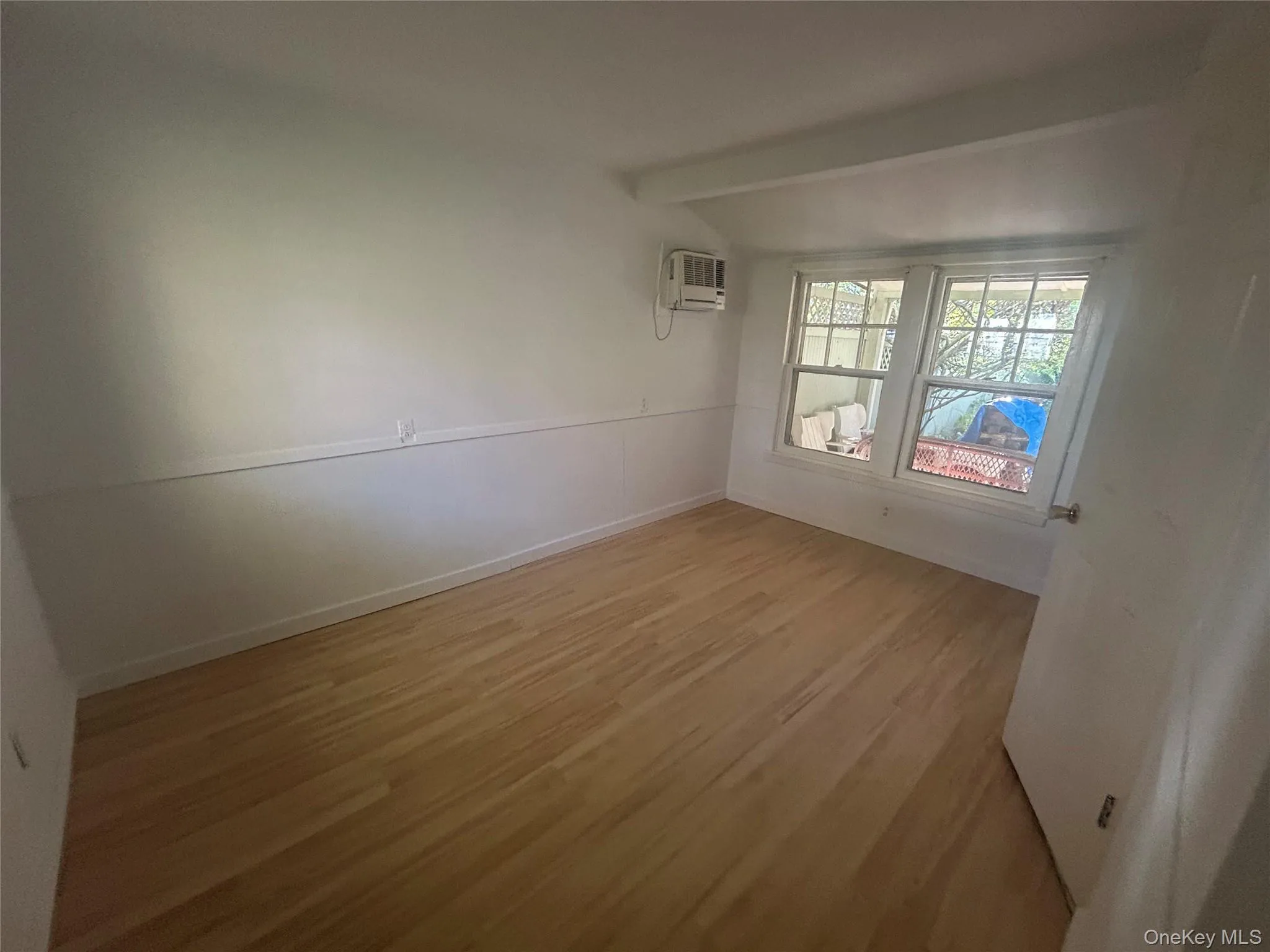 Spare room with light wood-style floors and baseboards Spare room with light wood-style floors and baseboards