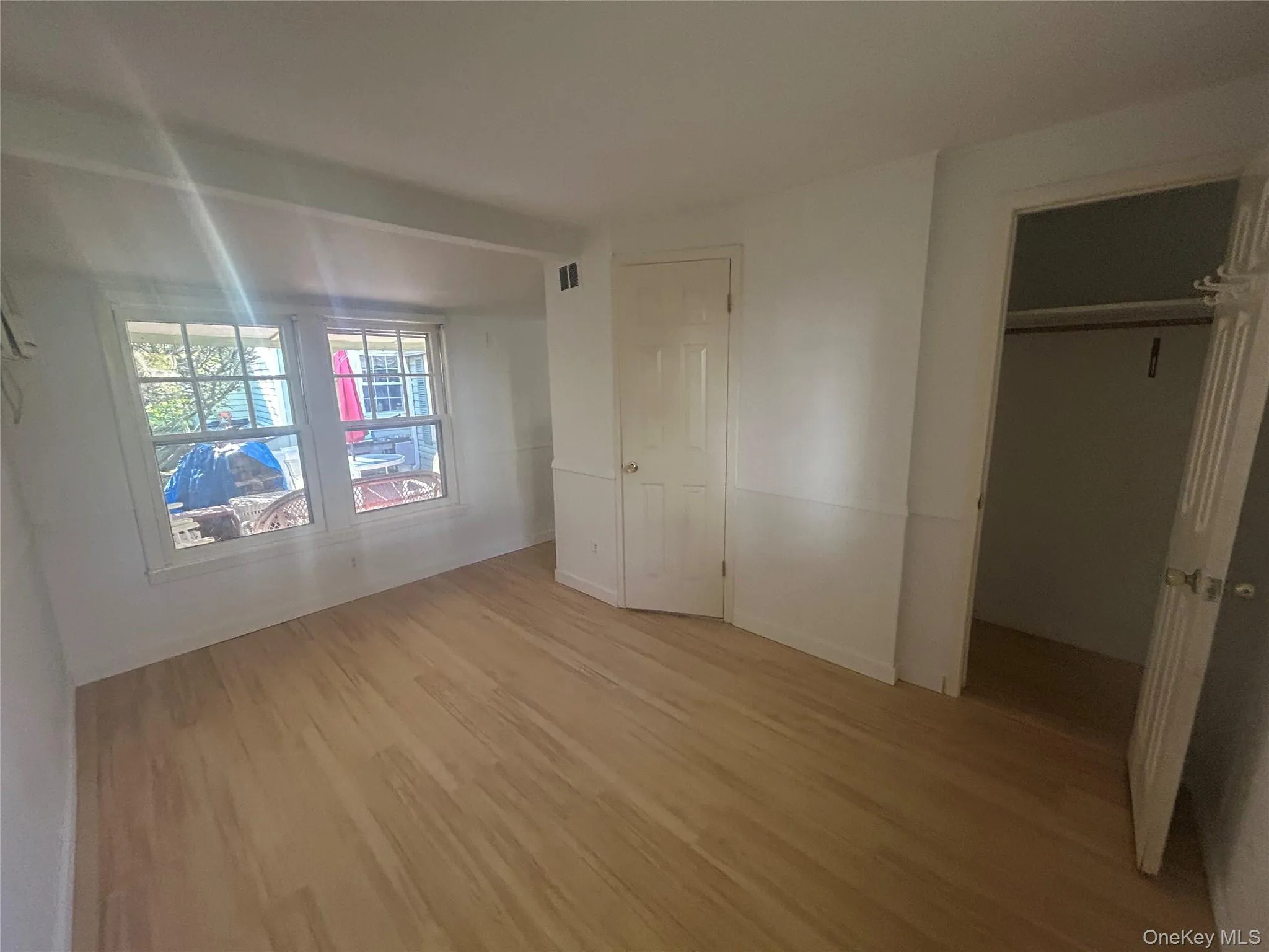 Unfurnished bedroom featuring a closet and light wood-style floors Unfurnished bedroom featuring a closet and light wood-style floors