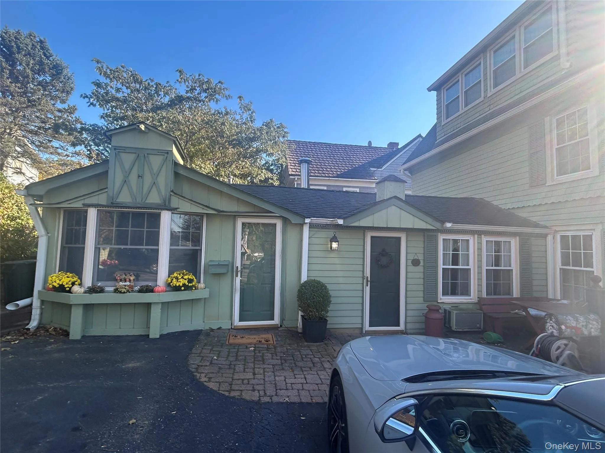View of front of house featuring a shingled roof, board and batten siding, and a patio area View of front of house featuring a shingled roof, board and batten siding, and a patio area