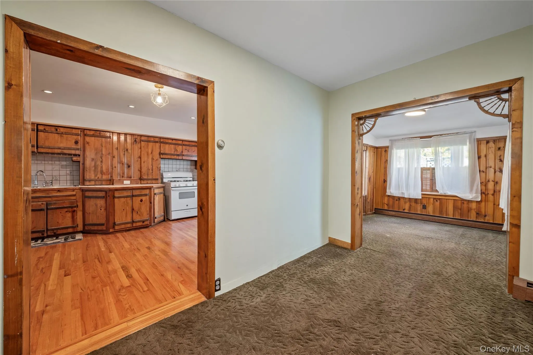 Spare room featuring baseboard heating and light carpet Spare room featuring baseboard heating and light carpet