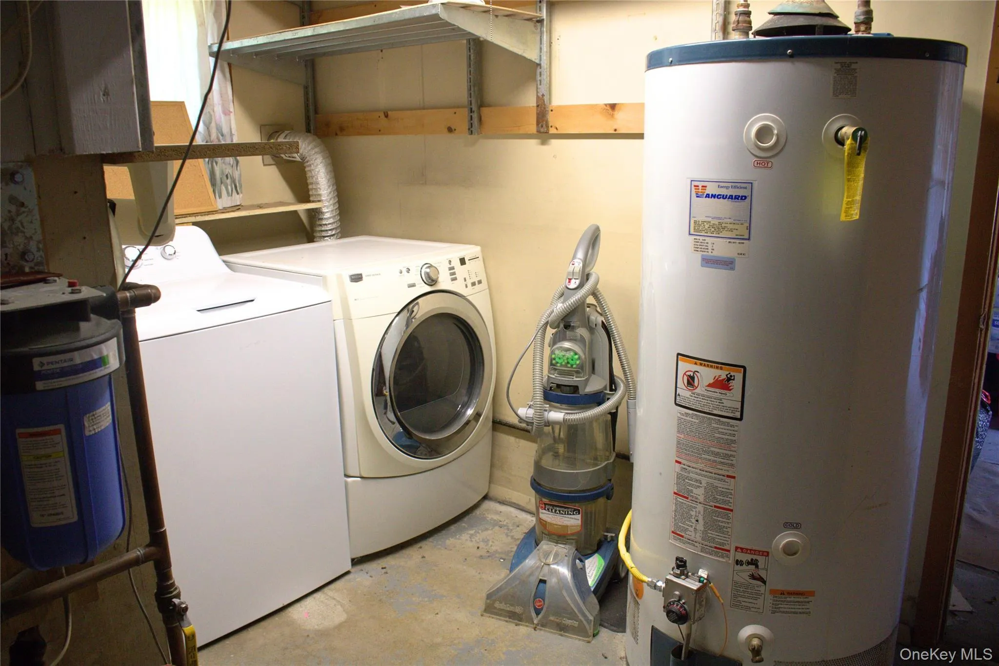 Laundry room featuring gas water heater, washer and clothes dryer, and unfinished concrete floors Laundry room featuring gas water heater, washer and clothes dryer, and unfinished concrete floors