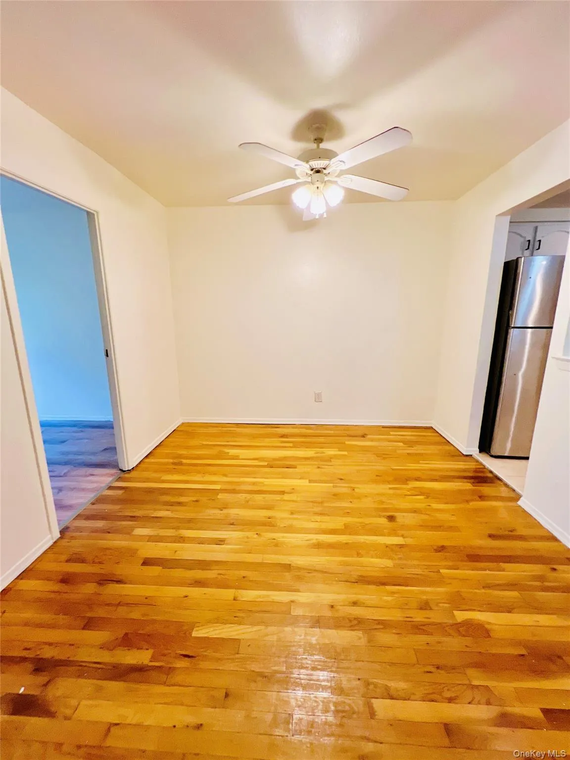 Unfurnished room with light wood finished floors and ceiling fan Unfurnished room with light wood finished floors and ceiling fan