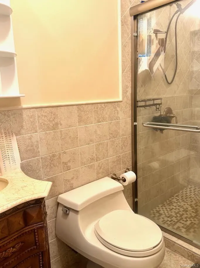 Full bathroom with vanity, tile walls, and a stall shower Full bathroom with vanity, tile walls, and a stall shower