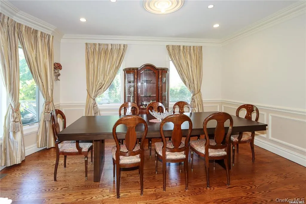 Dining room with a decorative wall, a wainscoted wall, wood finished floors, crown molding, and recessed lighting Dining room with a decorative wall, a wainscoted wall, wood finished floors, crown molding, and recessed lighting