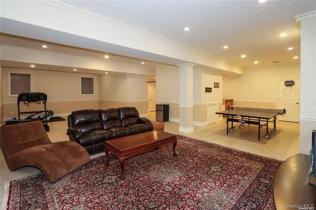 Living room featuring ornamental molding, recessed lighting, and light tile patterned floors Living room featuring ornamental molding, recessed lighting, and light tile patterned floors