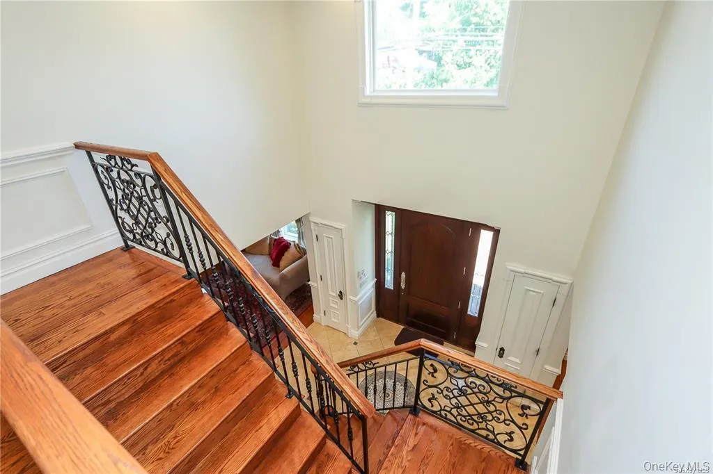 Entryway featuring stairs, wood finished floors, a decorative wall, and a wainscoted wall Entryway featuring stairs, wood finished floors, a decorative wall, and a wainscoted wall