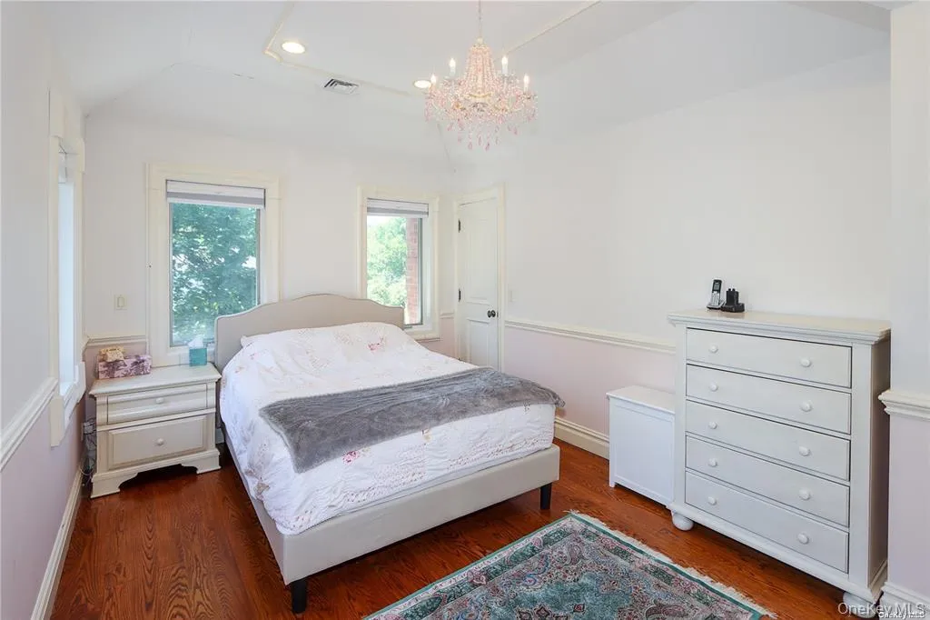 Bedroom featuring recessed lighting, wood finished floors, a chandelier, and vaulted ceiling Bedroom featuring recessed lighting, wood finished floors, a chandelier, and vaulted ceiling
