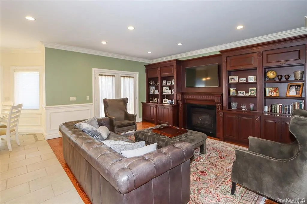 Living area with crown molding, recessed lighting, a fireplace, a wainscoted wall, and a decorative wall Living area with crown molding, recessed lighting, a fireplace, a wainscoted wall, and a decorative wall