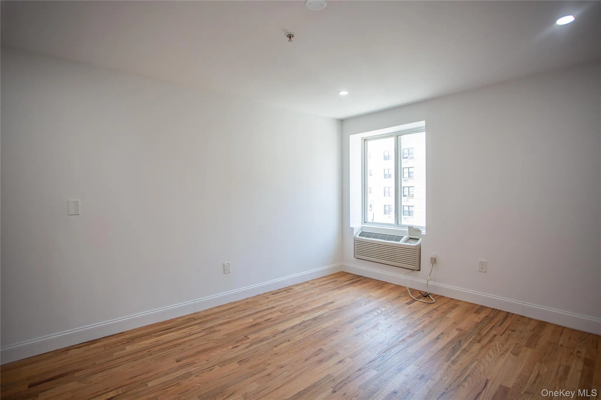 Empty room with light wood-style floors and recessed lighting Empty room with light wood-style floors and recessed lighting