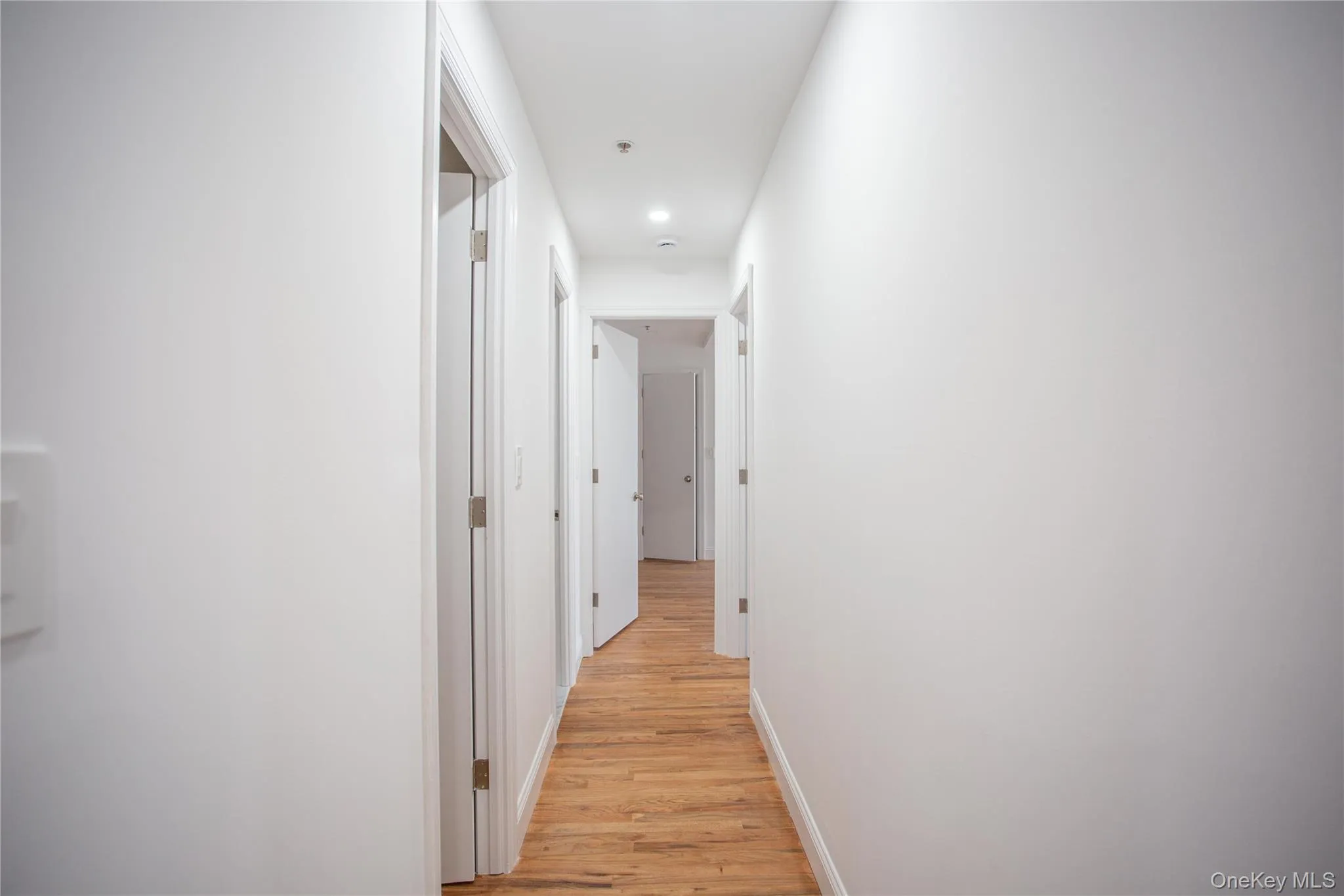 Hallway with light wood finished floors and baseboards Hallway with light wood finished floors and baseboards