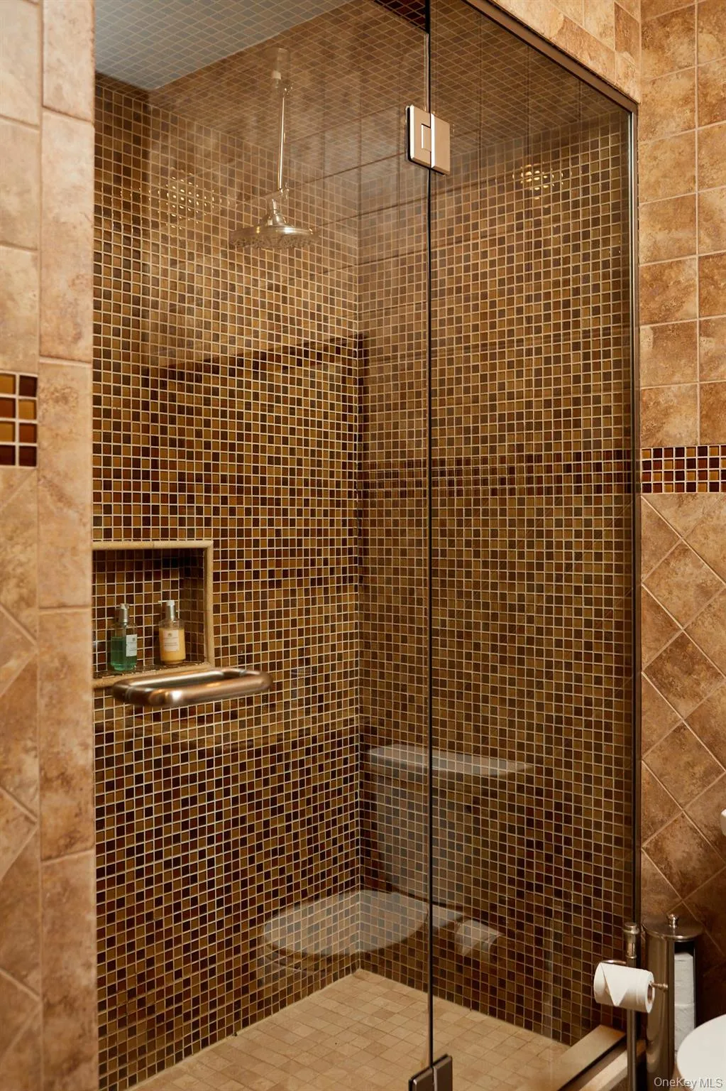 Bathroom featuring a stall shower and tile walls Bathroom featuring a stall shower and tile walls