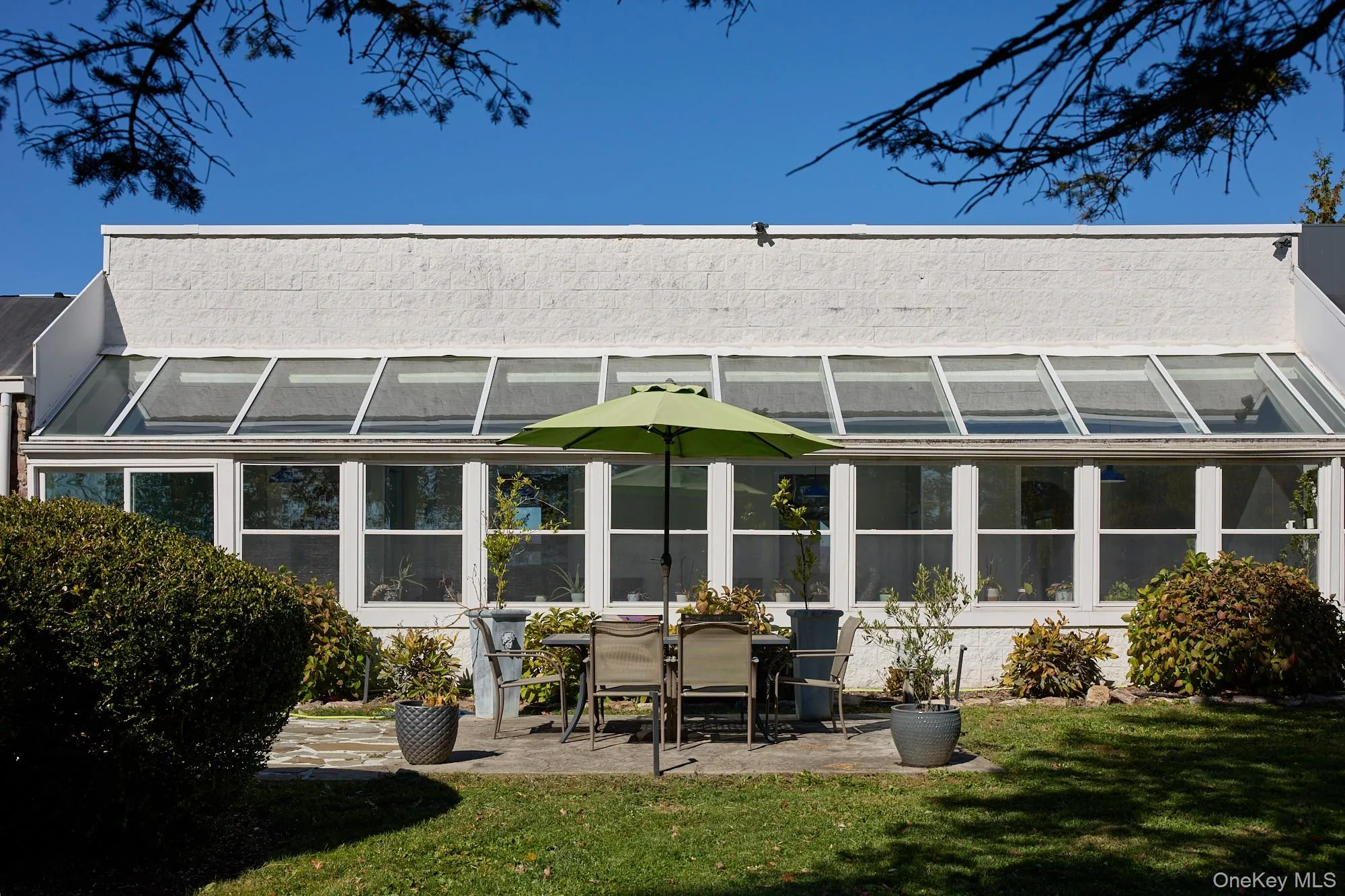 Back of house featuring a sunroom, a patio, and a lawn Back of house featuring a sunroom, a patio, and a lawn