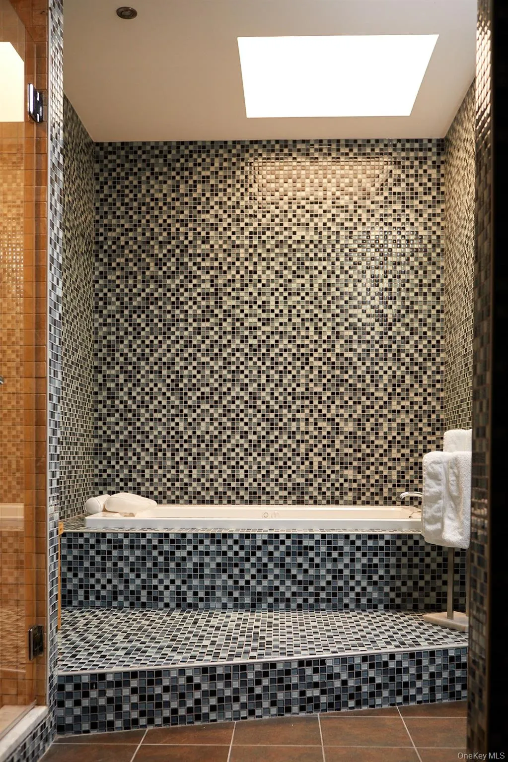Bathroom featuring a shower stall, tile patterned flooring, tiled tub, and tile walls Bathroom featuring a shower stall, tile patterned flooring, tiled tub, and tile walls