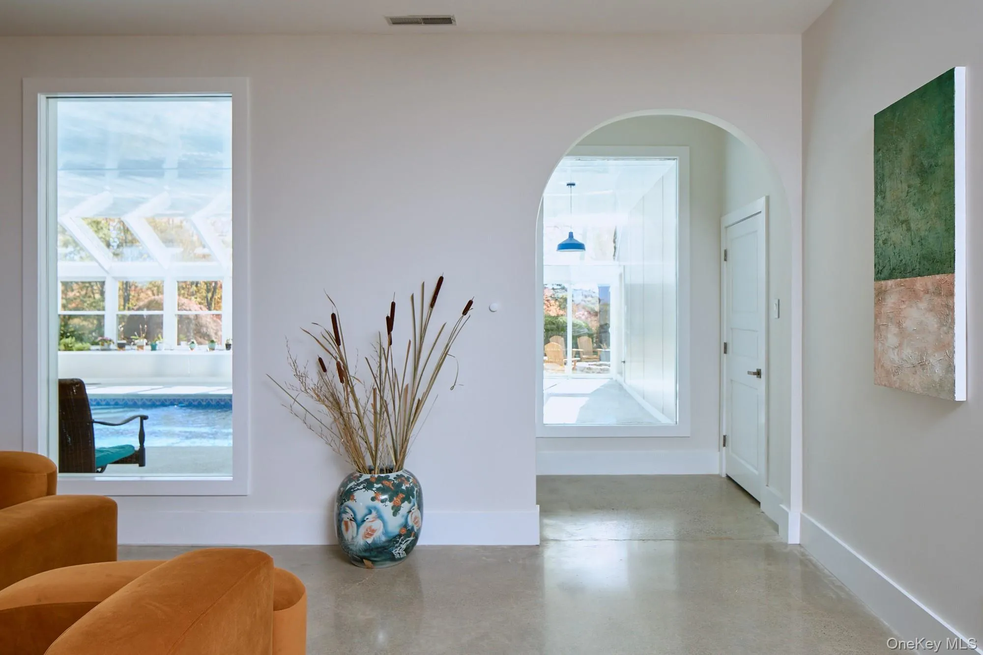 Sitting room featuring finished concrete floors and baseboards Sitting room featuring finished concrete floors and baseboards