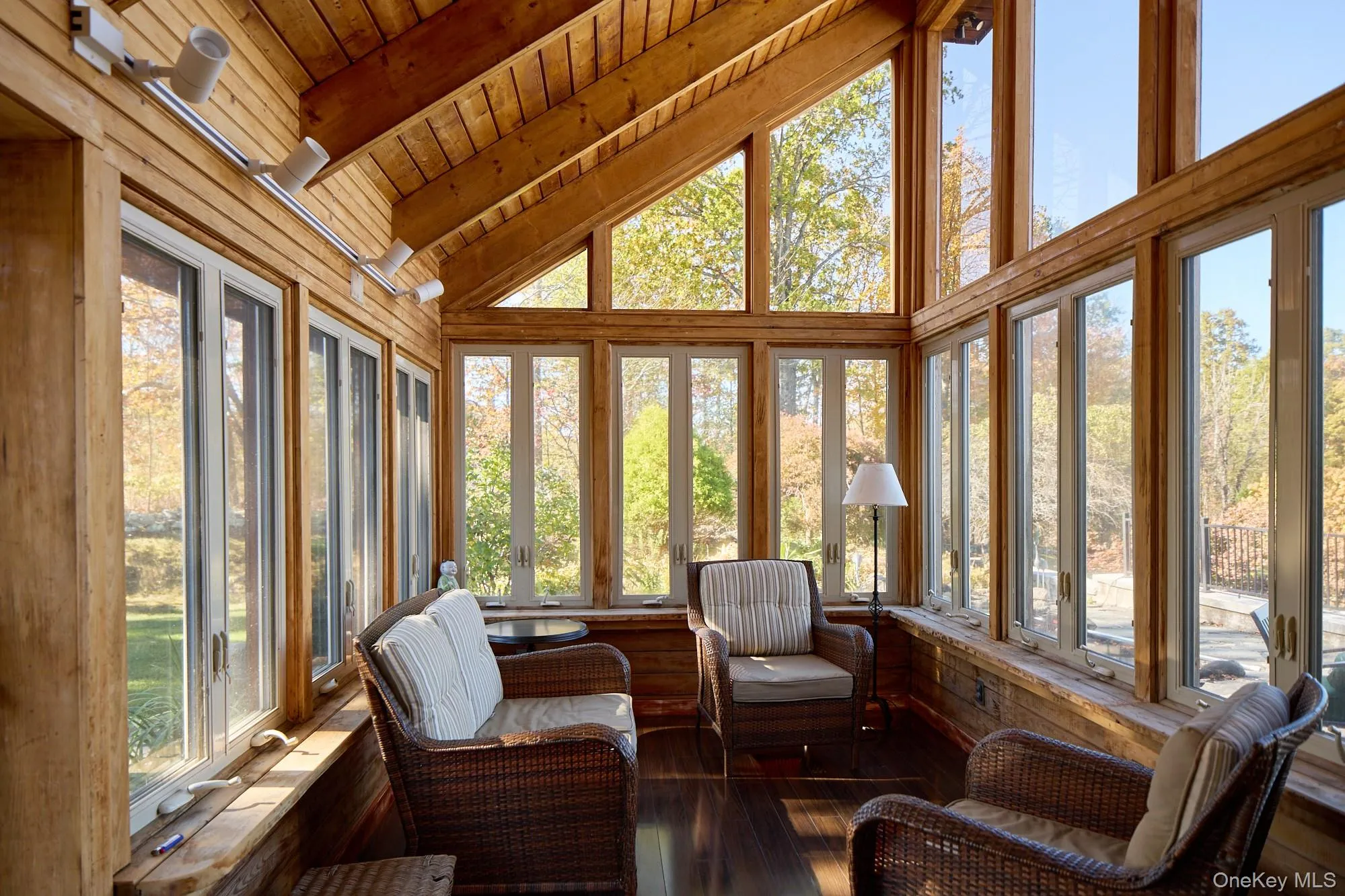 Sunroom / solarium with healthy amount of natural light, hardwood / wood-style flooring, a wood ceiling with exposed beams, and high vaulted ceiling Sunroom / solarium with healthy amount of natural light, hardwood / wood-style flooring, a wood ceiling with exposed beams, and high vaulted ceiling
