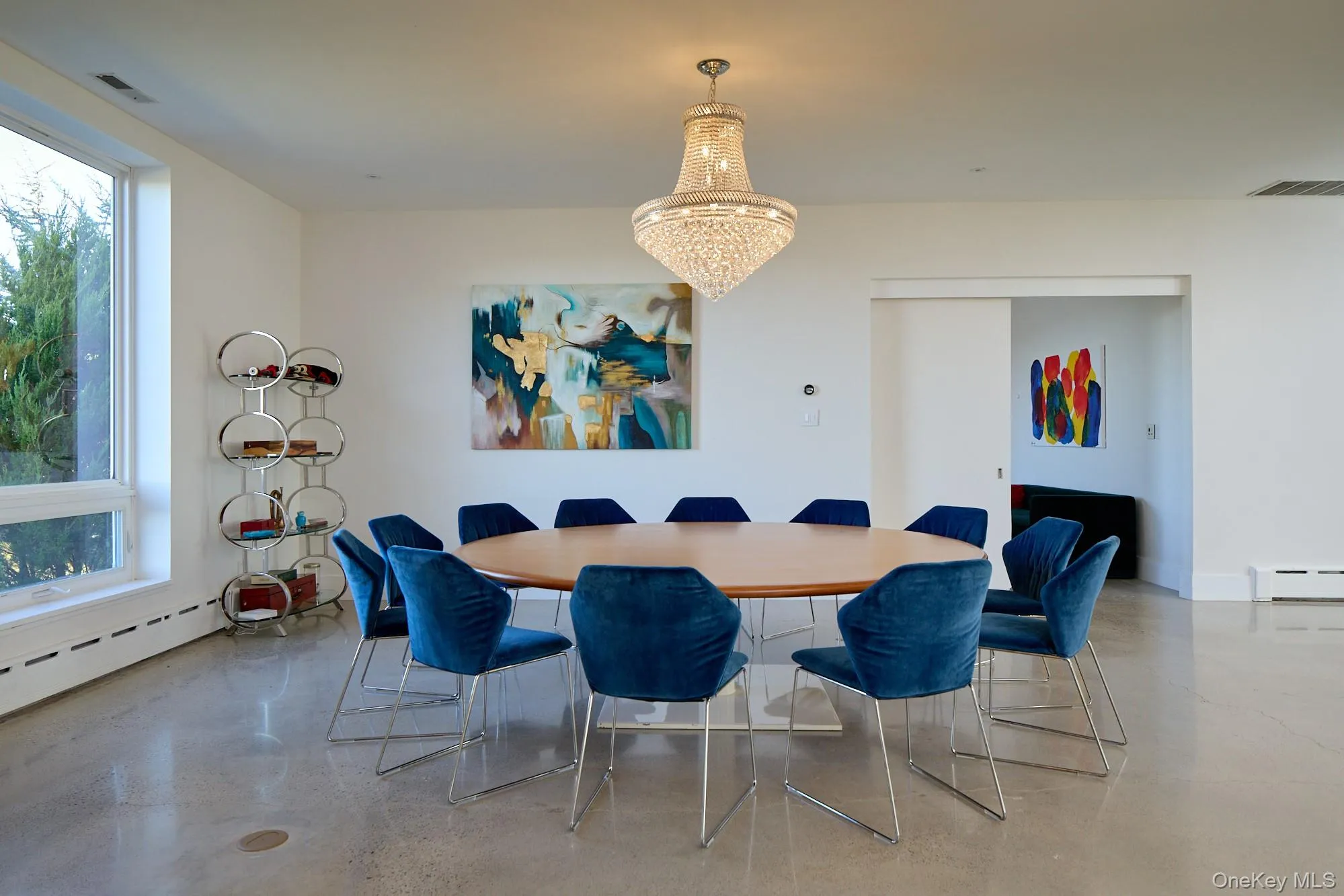 Dining space featuring plenty of natural light, a chandelier, finished concrete flooring, and baseboard heating Dining space featuring plenty of natural light, a chandelier, finished concrete flooring, and baseboard heating