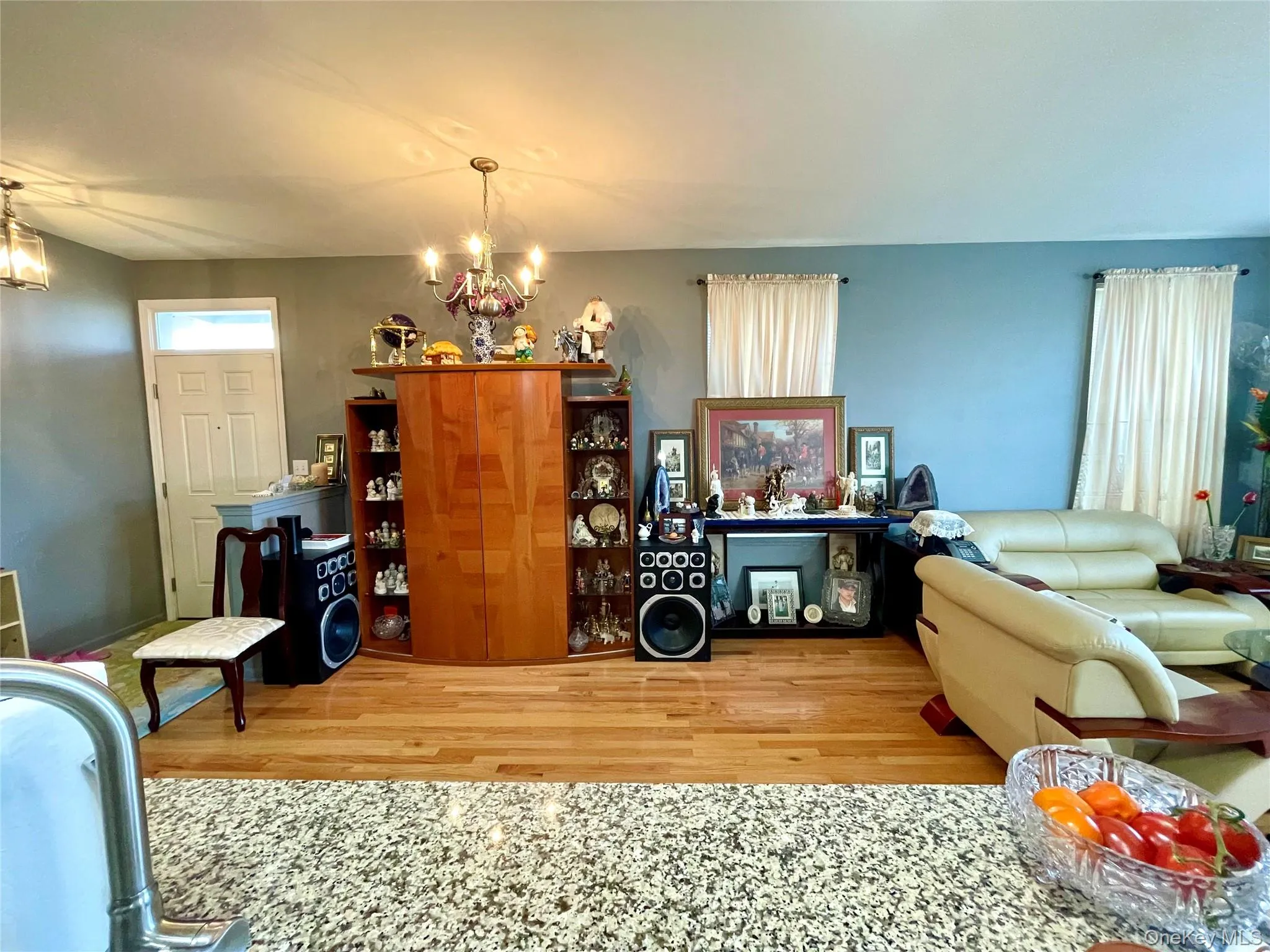 Living area with a chandelier and wood finished floors Living area with a chandelier and wood finished floors