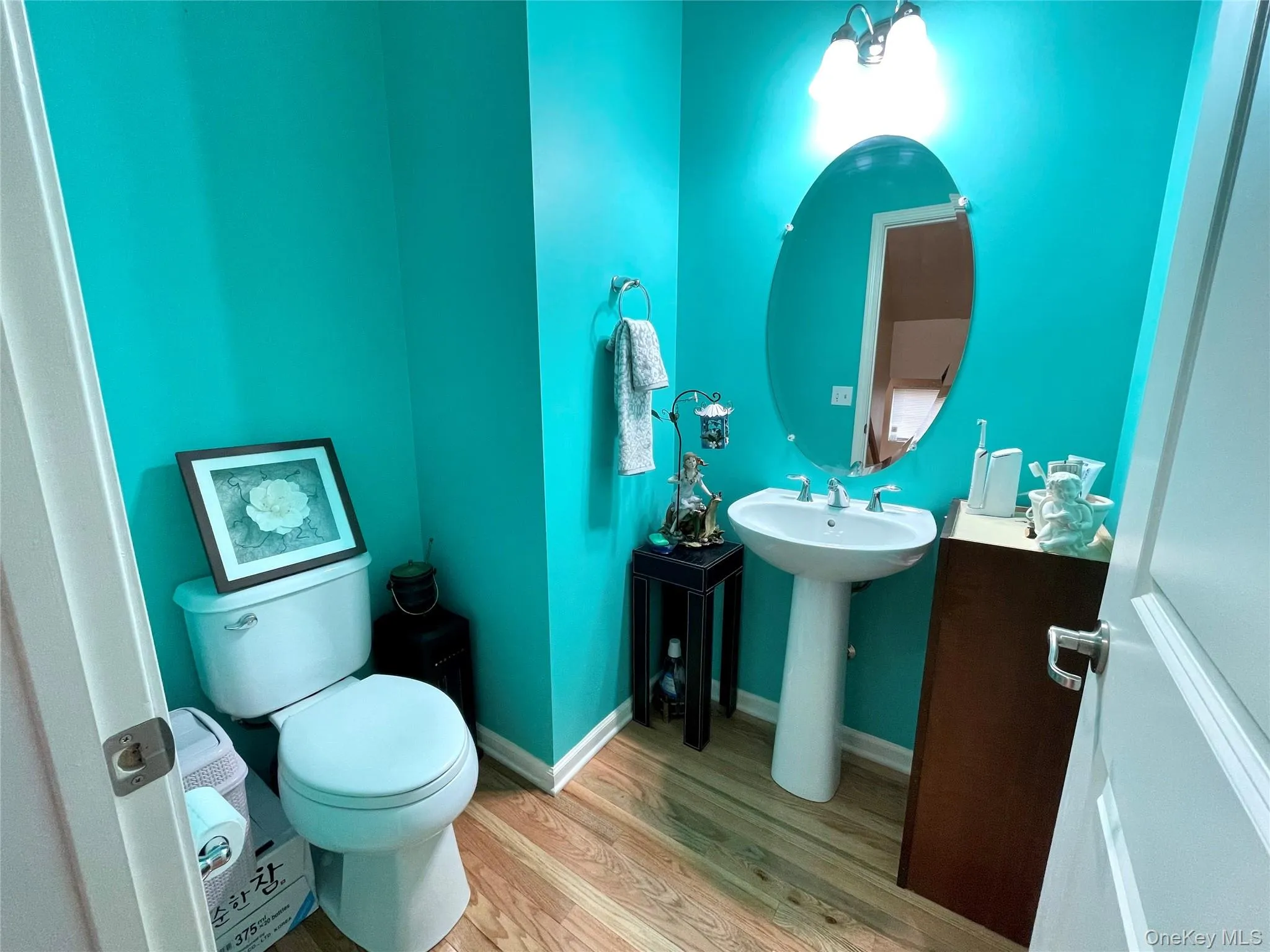 Bathroom featuring baseboards and light wood-type flooring Bathroom featuring baseboards and light wood-type flooring