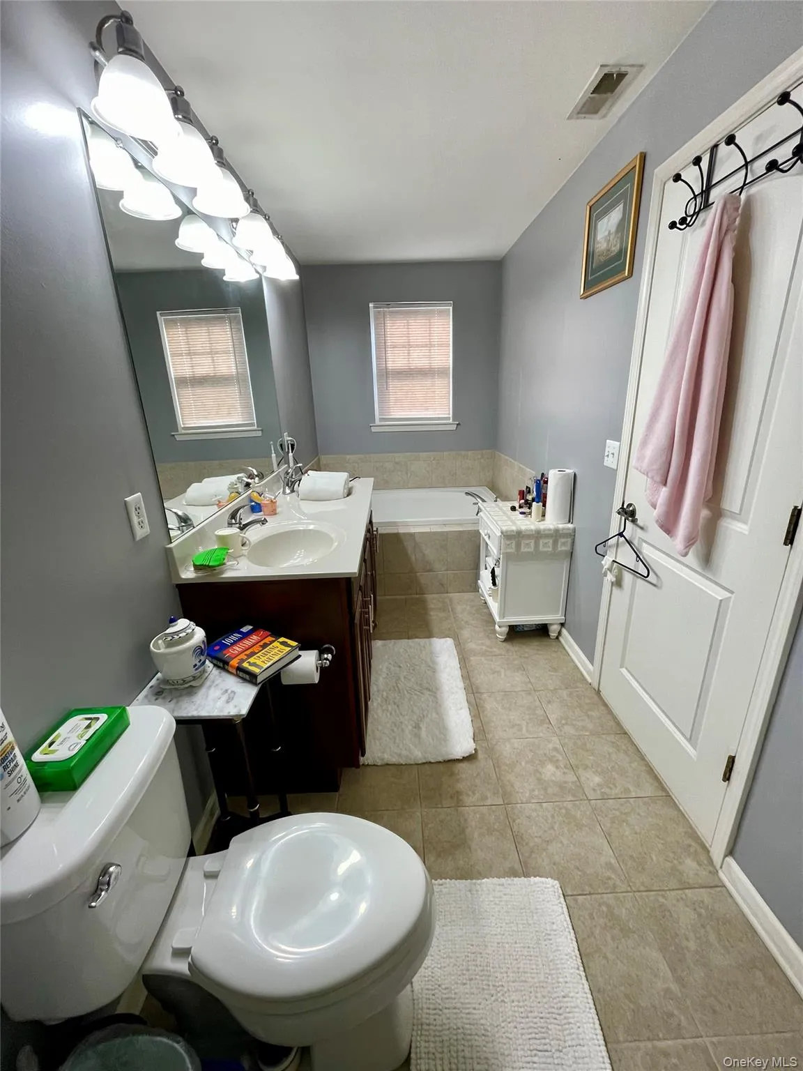 Full bath with double vanity, light tile patterned floors, and a bath Full bath with double vanity, light tile patterned floors, and a bath