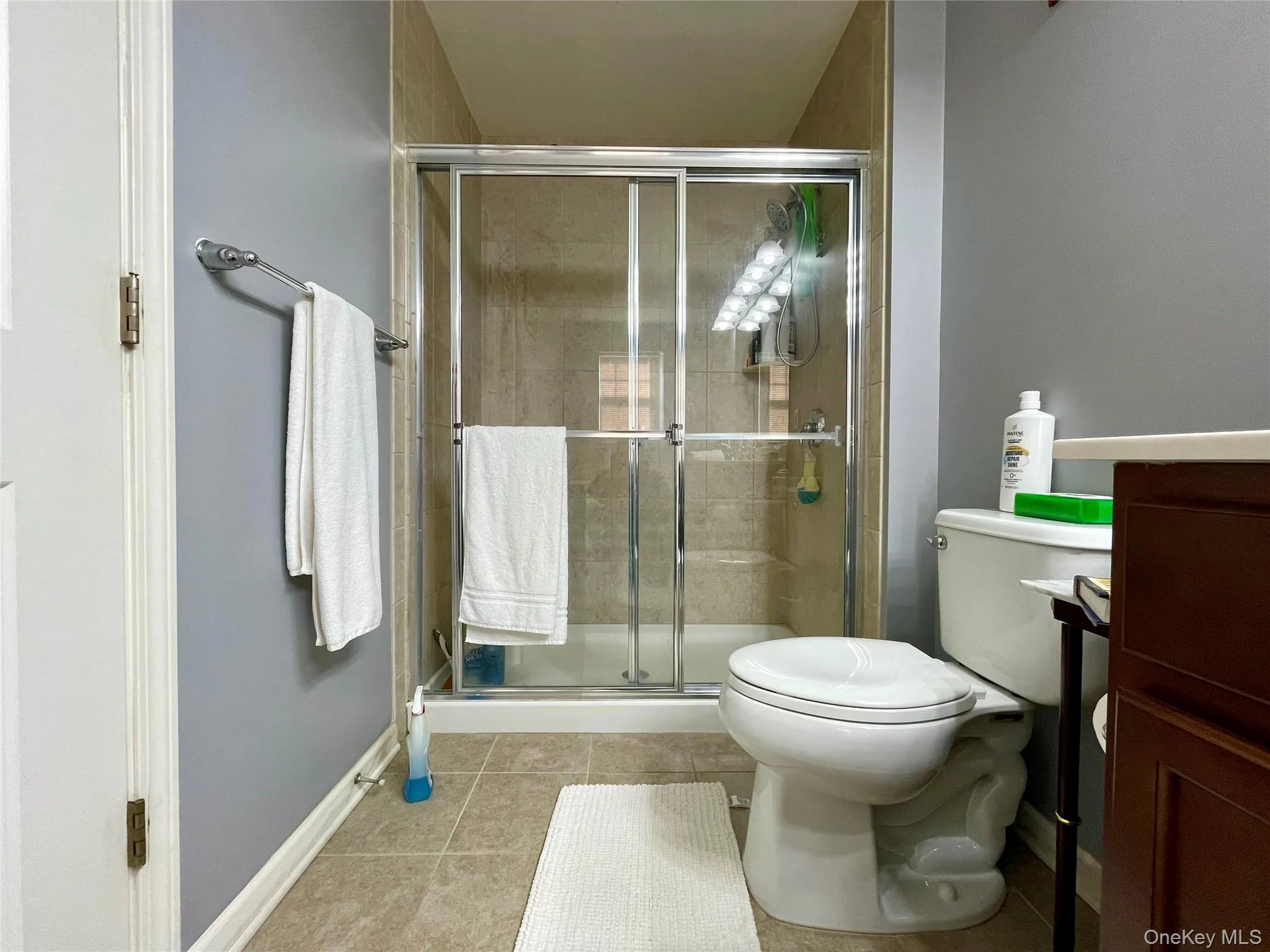 Full bath with light tile patterned floors, a shower stall, and vanity Full bath with light tile patterned floors, a shower stall, and vanity