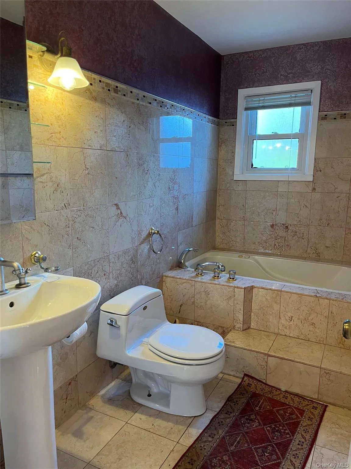 Bathroom featuring tile walls and a relaxing tiled tub Bathroom featuring tile walls and a relaxing tiled tub