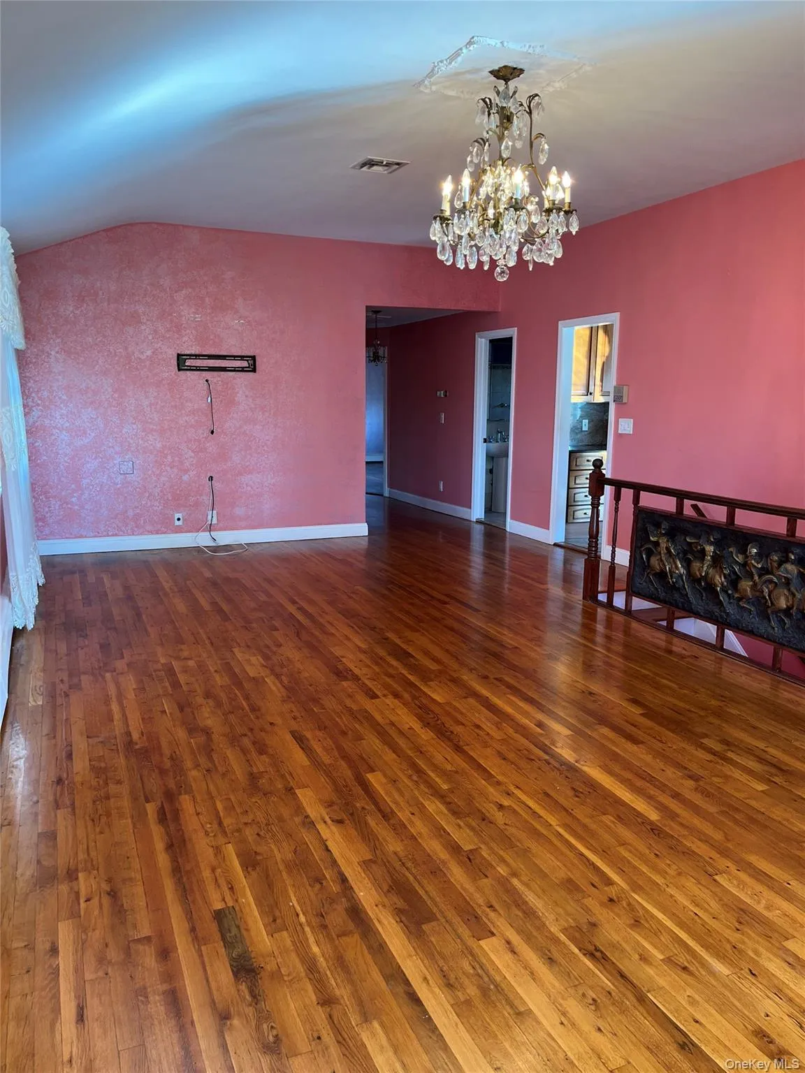 Empty room featuring dark wood finished floors and a chandelier Empty room featuring dark wood finished floors and a chandelier