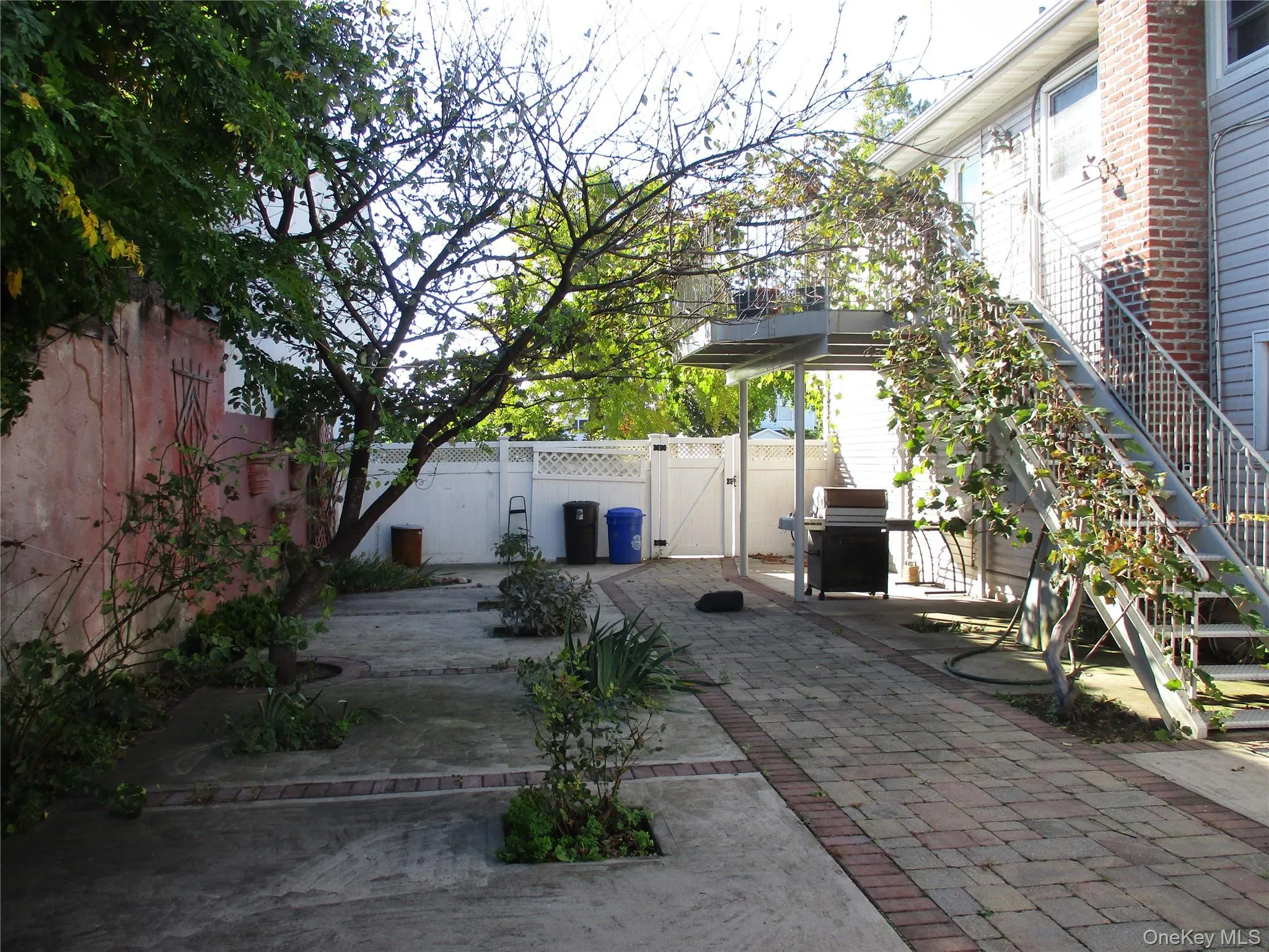 Fenced backyard featuring a gate, a patio, area for grilling, and stairs Fenced backyard featuring a gate, a patio, area for grilling, and stairs