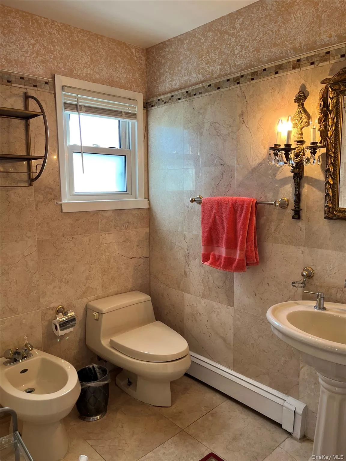 Half bath with tile walls, a baseboard heating unit, a bidet, and tile patterned floors Half bath with tile walls, a baseboard heating unit, a bidet, and tile patterned floors