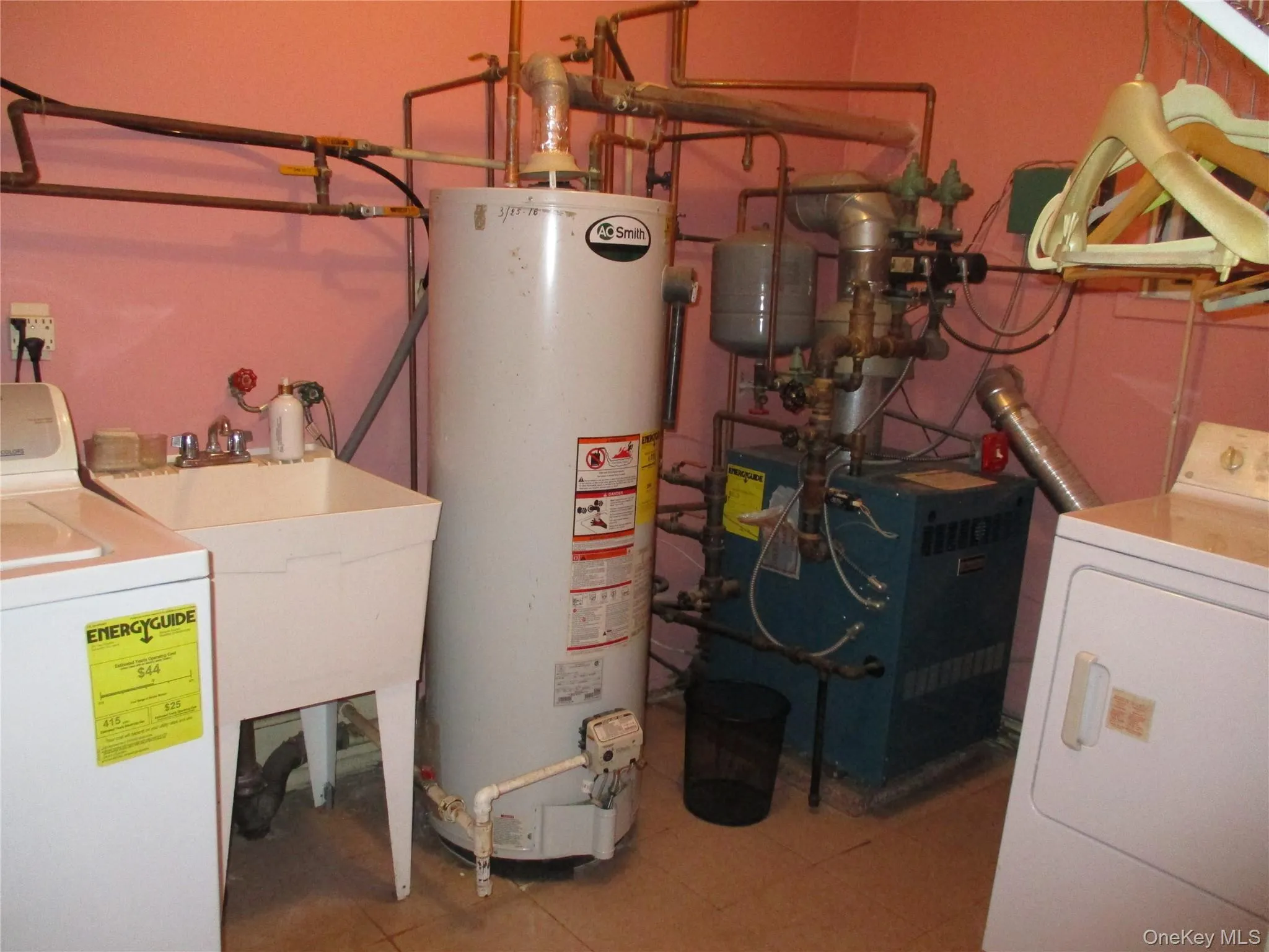 Utility room featuring washer / dryer, gas water heater, and a heating unit Utility room featuring washer / dryer, gas water heater, and a heating unit