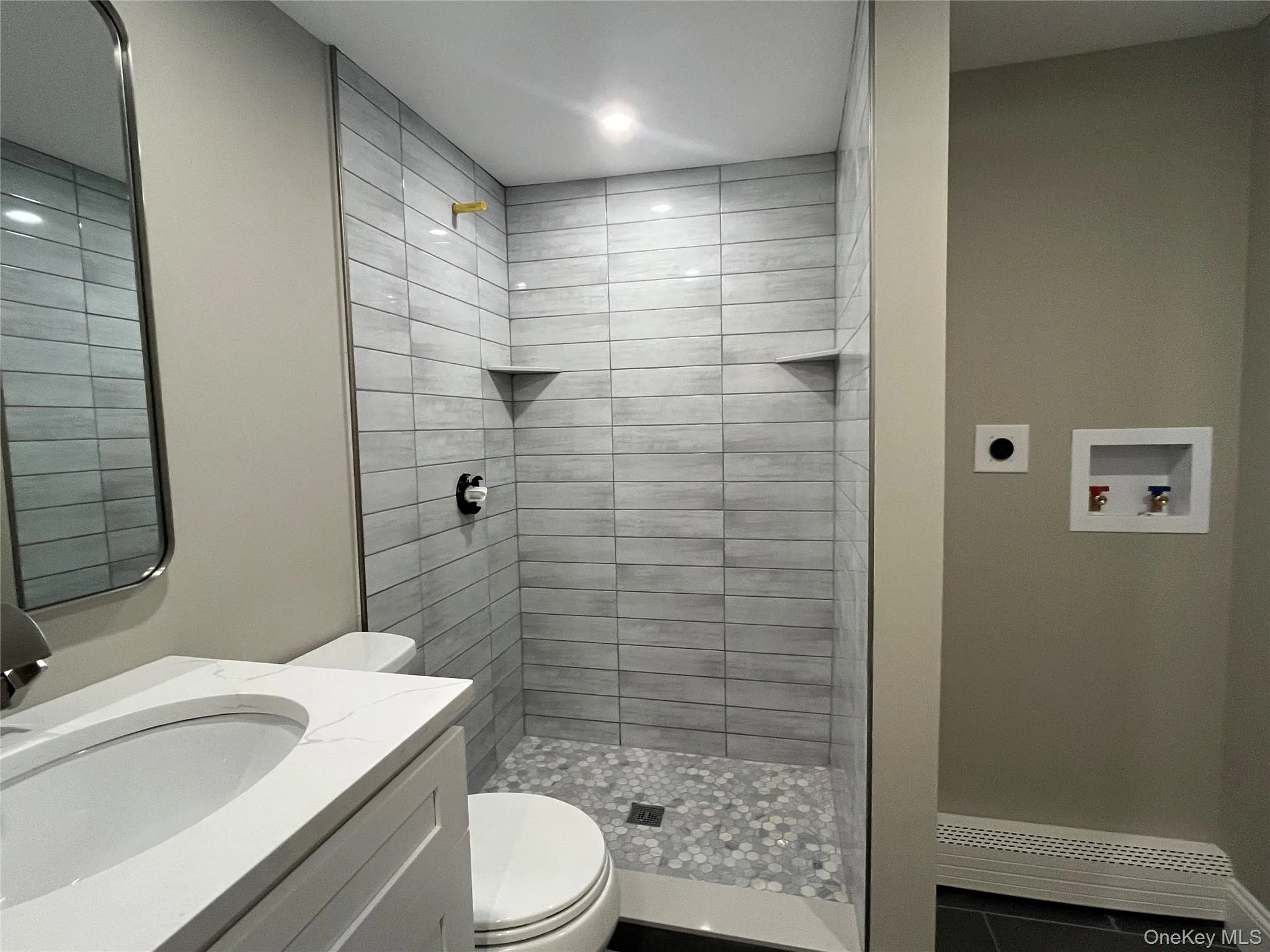 Bathroom with vanity, a shower stall, and dark tile patterned flooring Bathroom with vanity, a shower stall, and dark tile patterned flooring