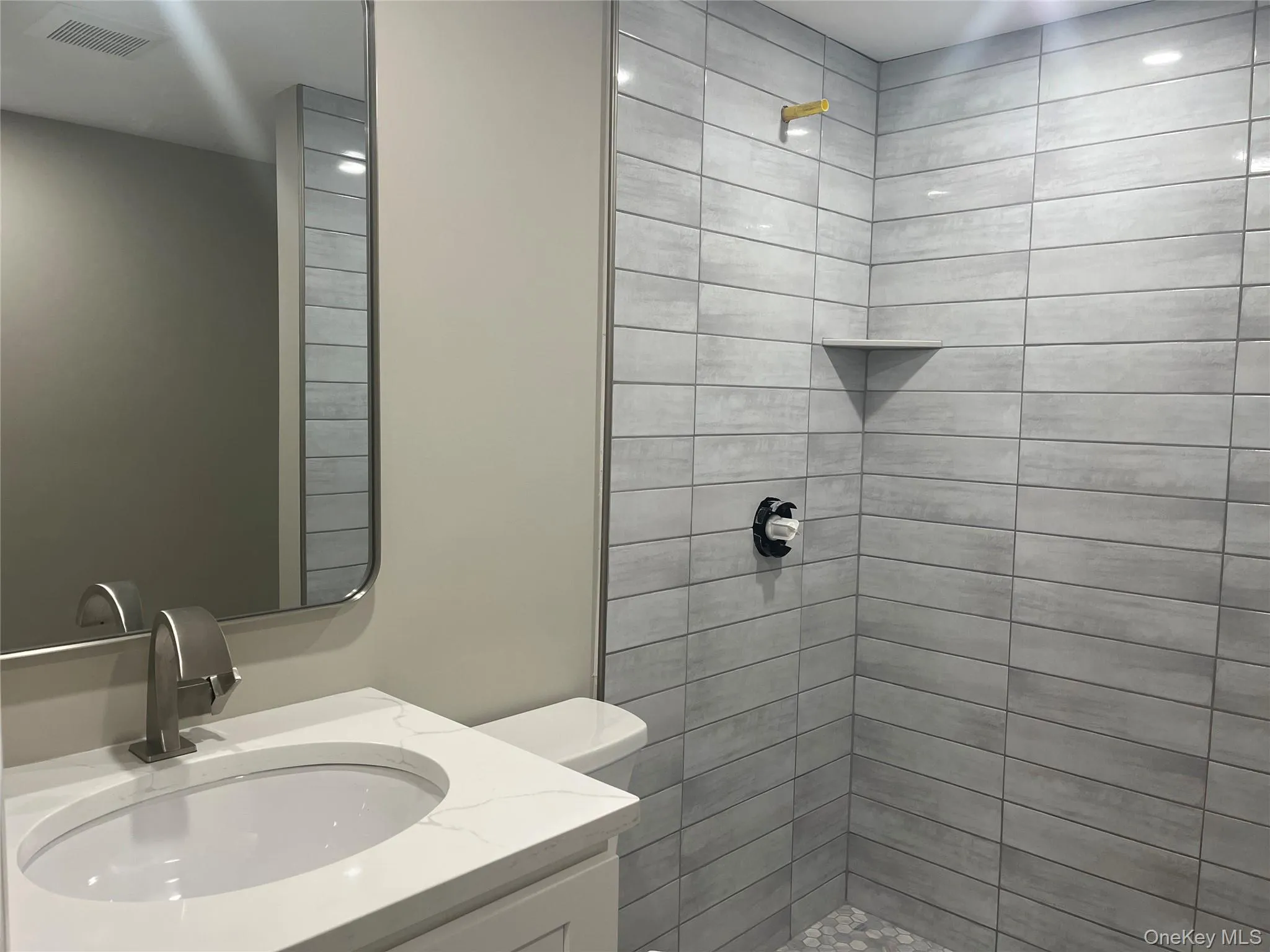 Full bath featuring vanity and a tile shower Full bath featuring vanity and a tile shower