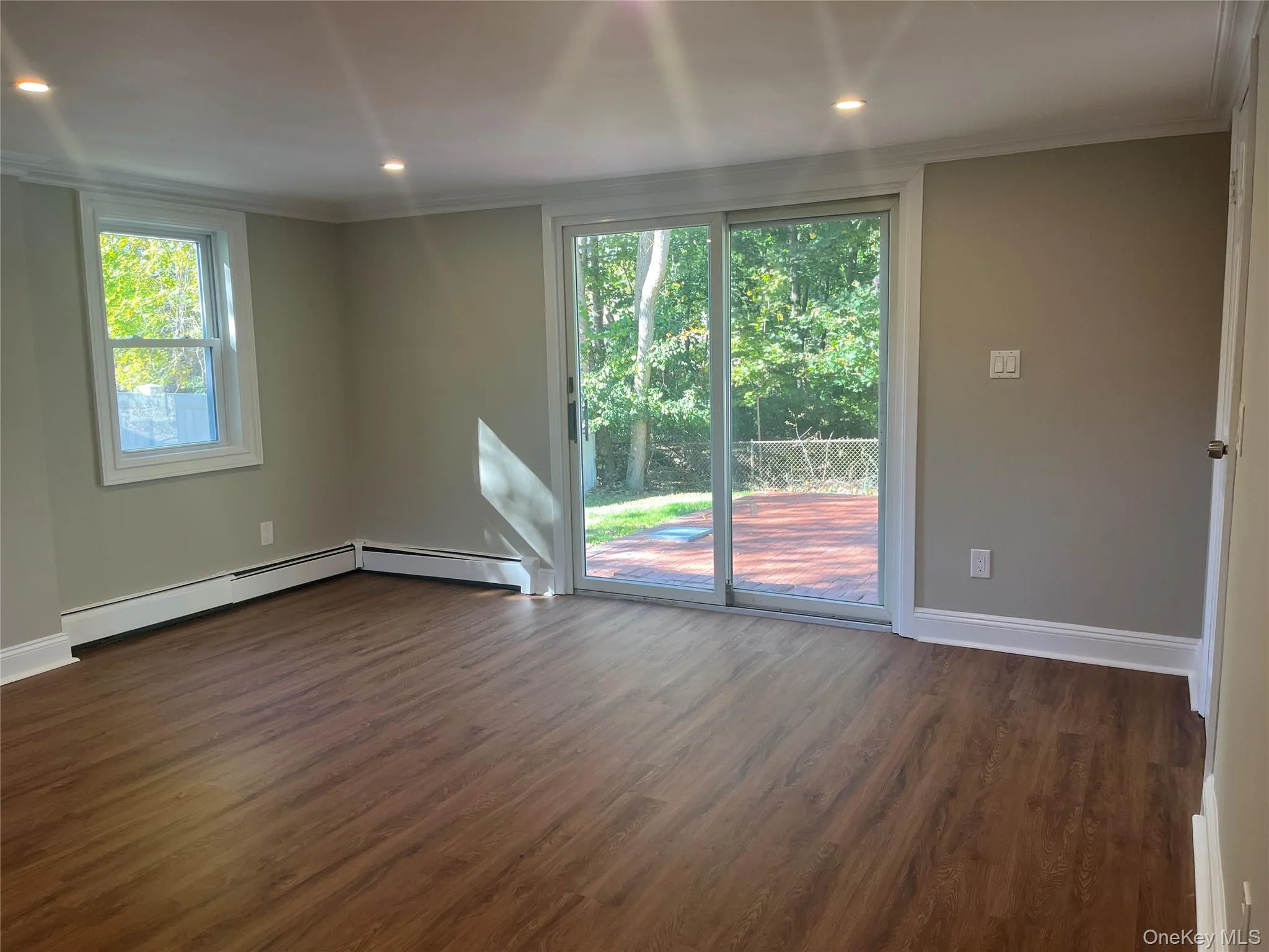 Empty room featuring dark wood-style floors, crown molding, and recessed lighting Empty room featuring dark wood-style floors, crown molding, and recessed lighting