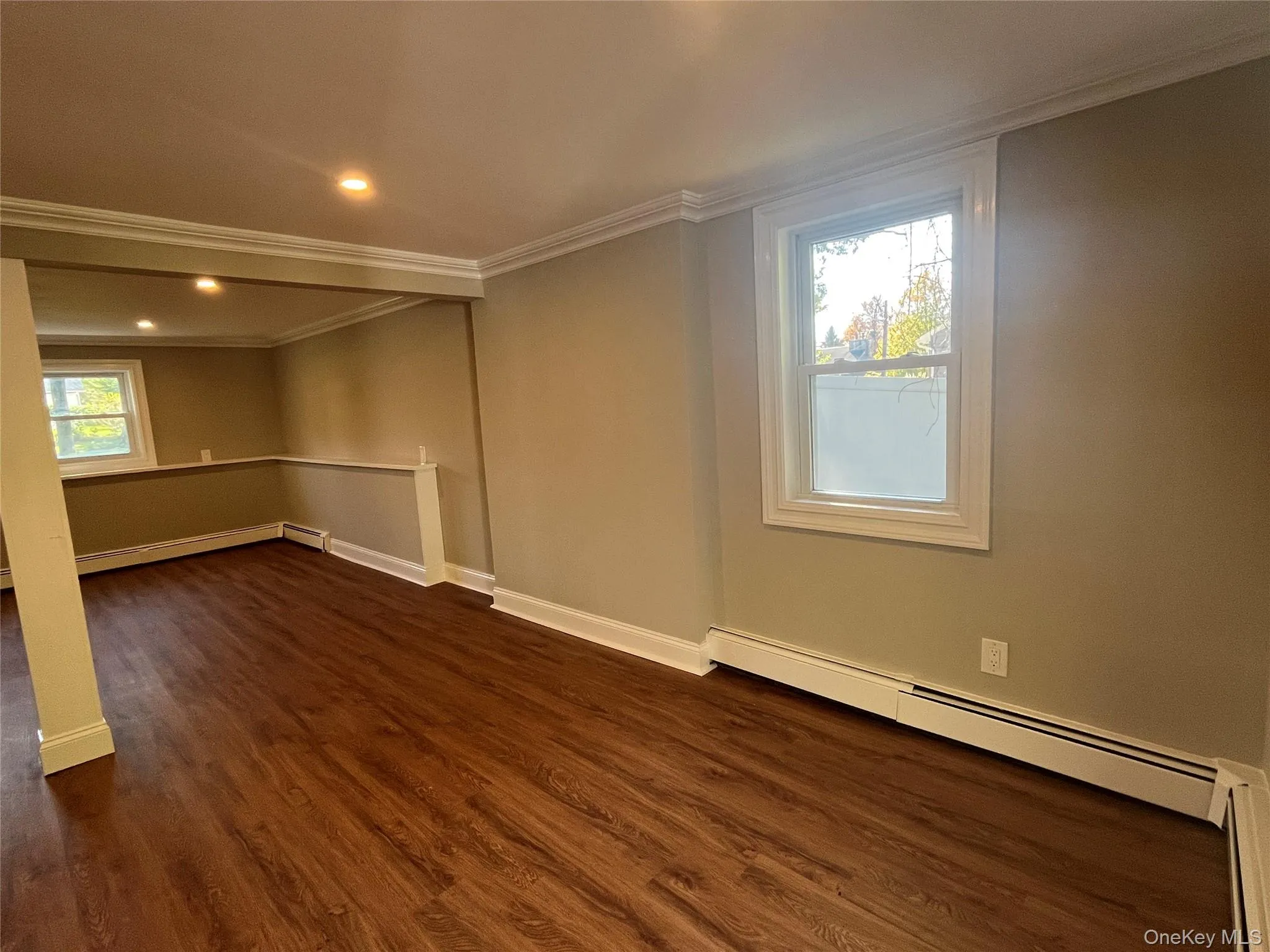Unfurnished room featuring ornamental molding, a baseboard radiator, dark wood-type flooring, and recessed lighting Unfurnished room featuring ornamental molding, a baseboard radiator, dark wood-type flooring, and recessed lighting