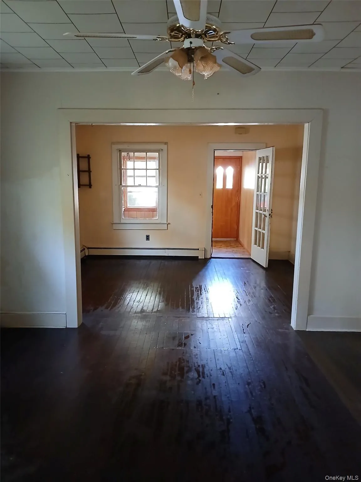 Foyer featuring dark wood-style floors, a ceiling fan, and a baseboard radiator Foyer featuring dark wood-style floors, a ceiling fan, and a baseboard radiator